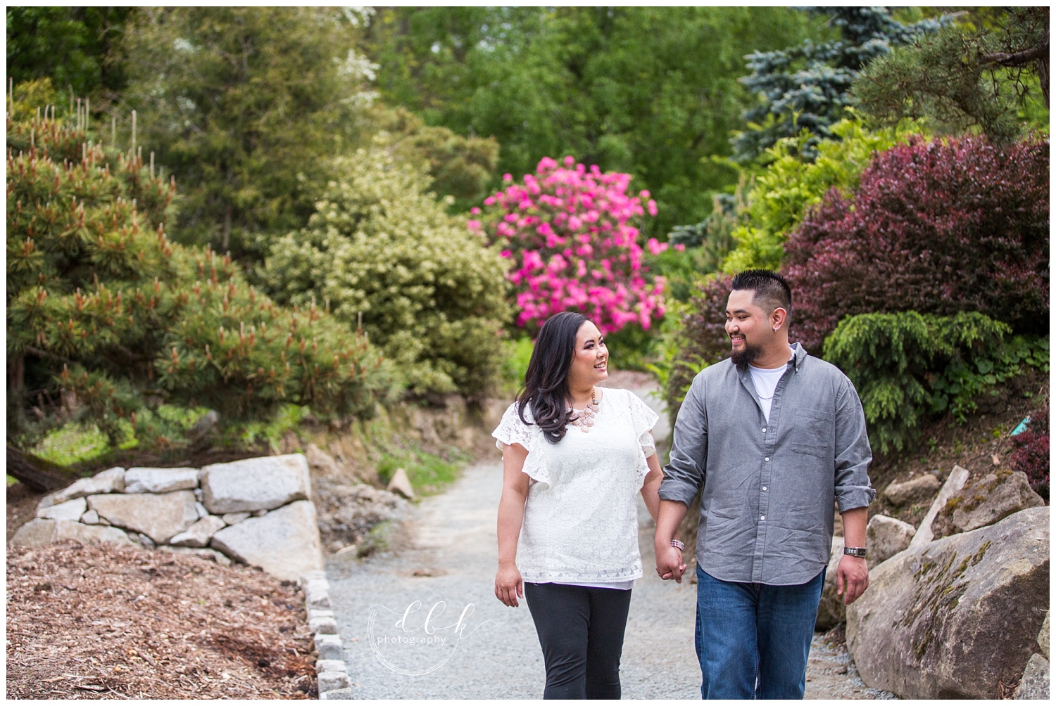 couple walking along paths in Kubota Garden for spring engagement portraits