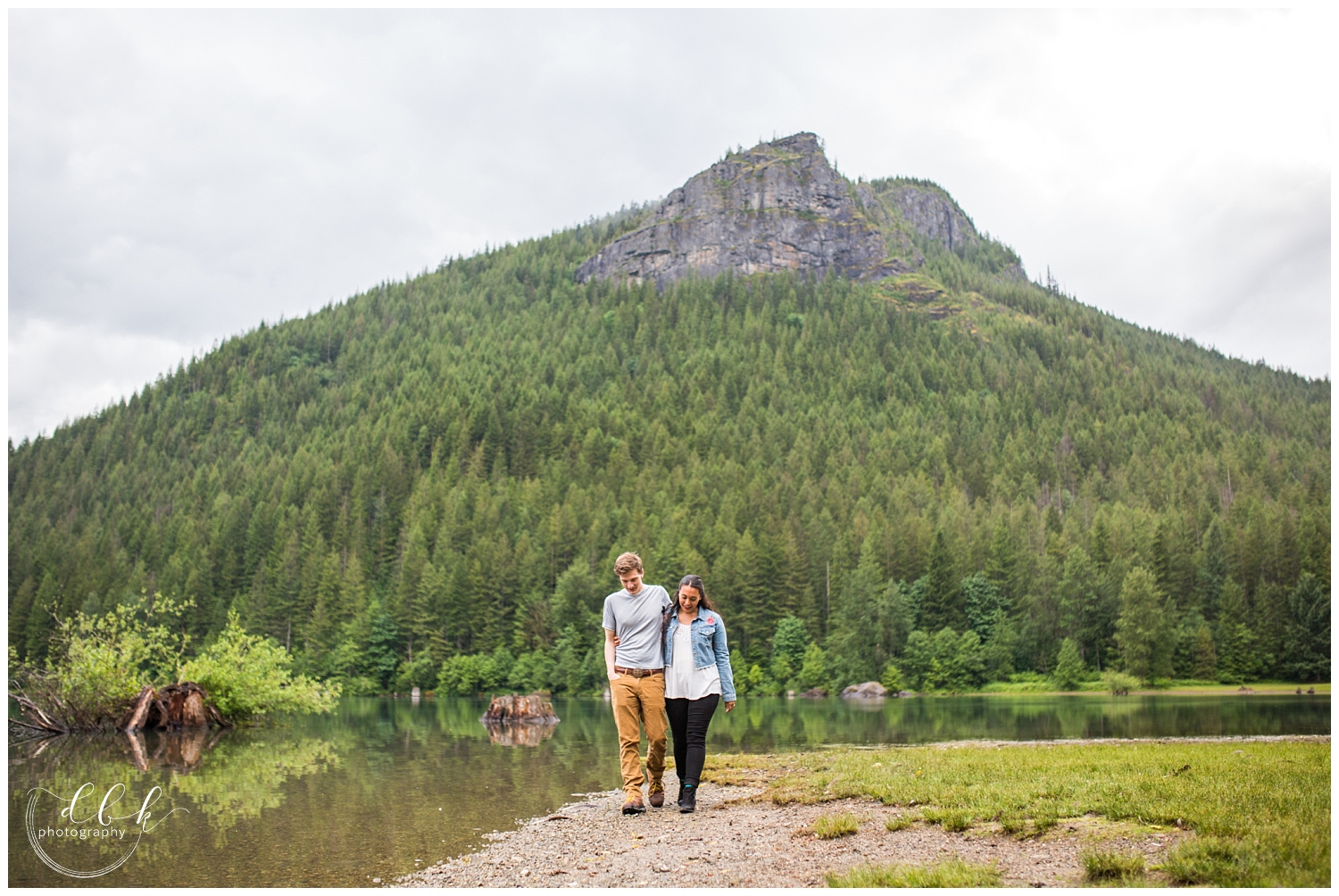 wide shot of couple walking arm in arm along the water at Rattlesnake Lake