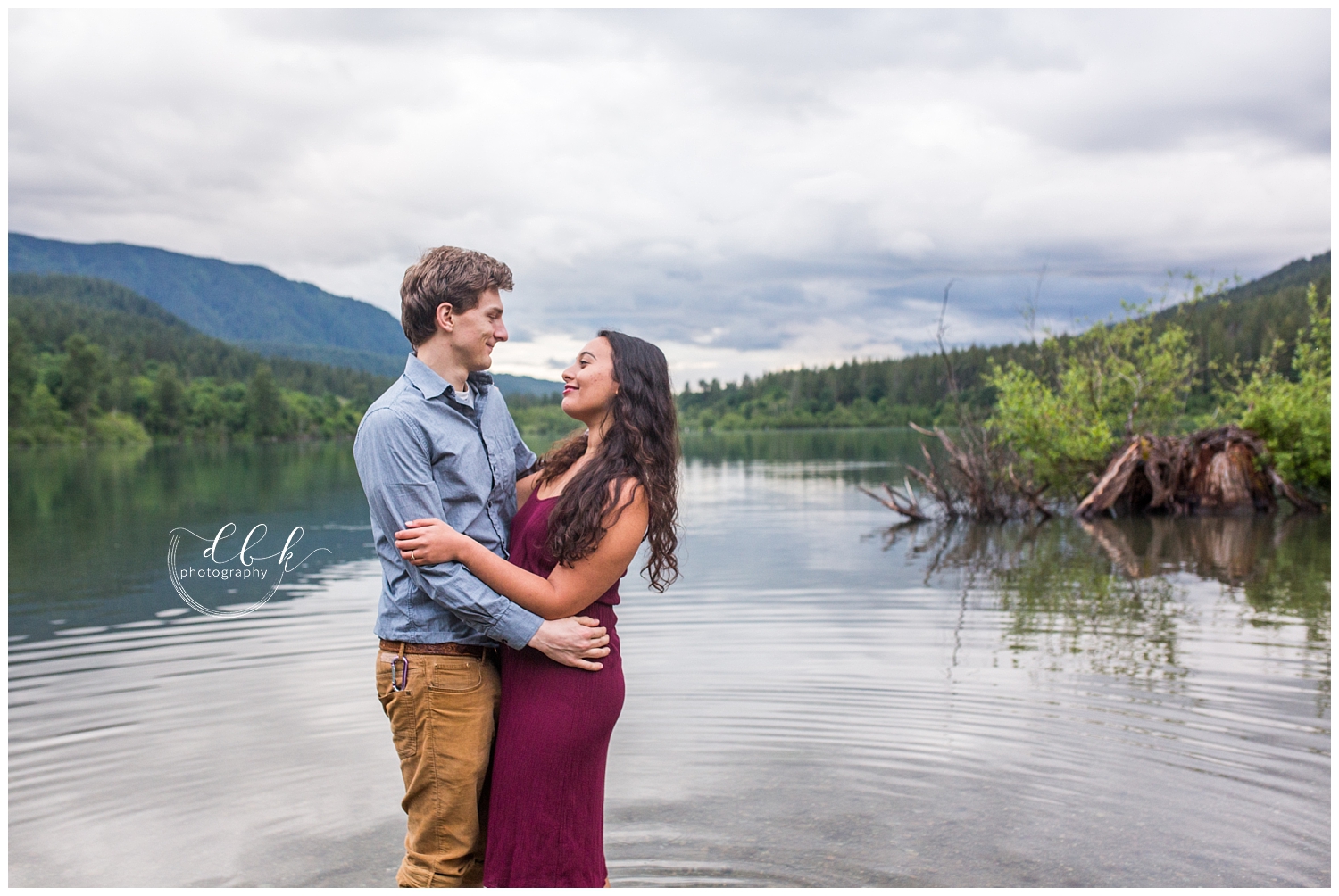 engaged couple faces each other in the water at Rattlesnake lake