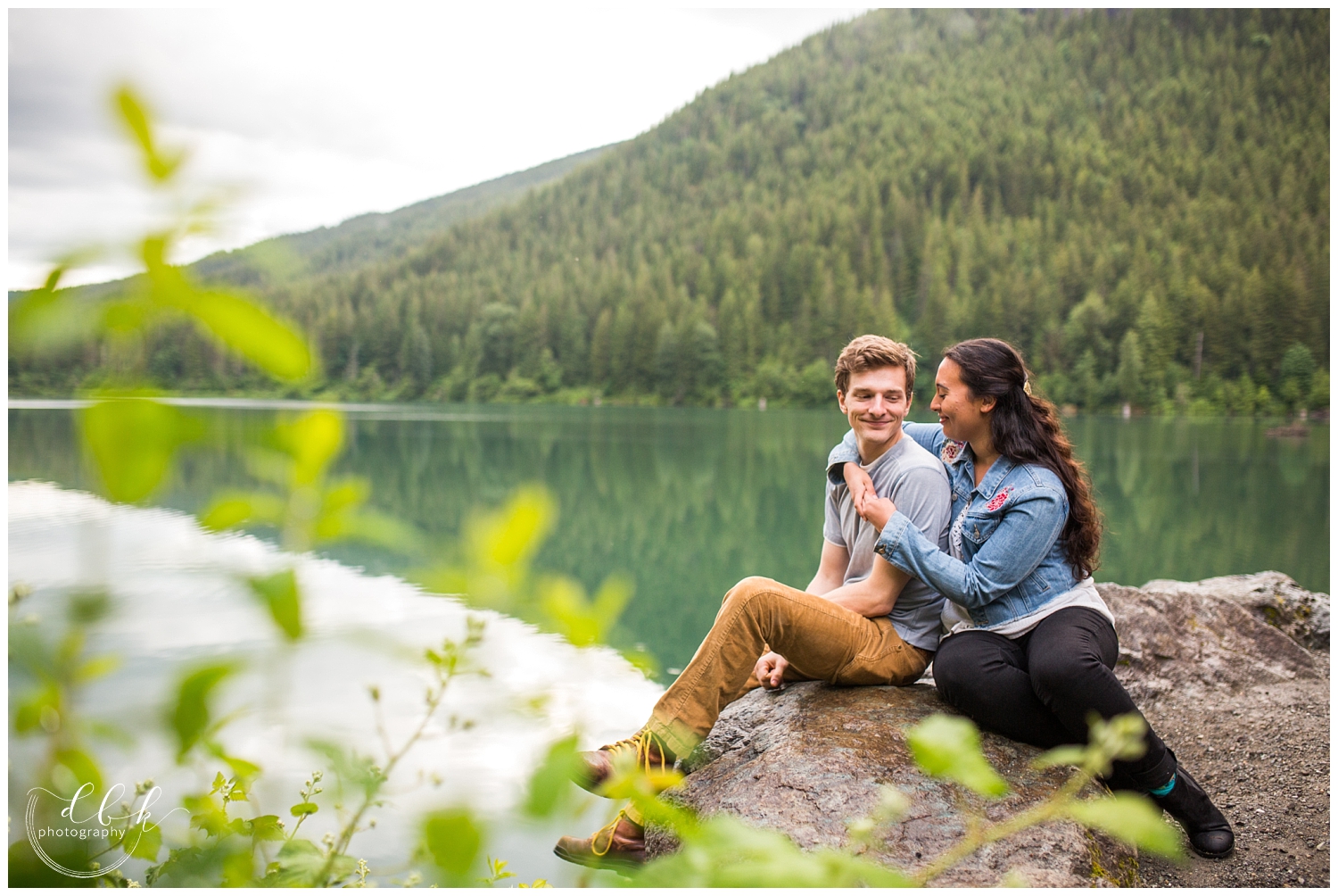 couple sitting on a boulder by Rattlesnake Lake in North Bend, Washington