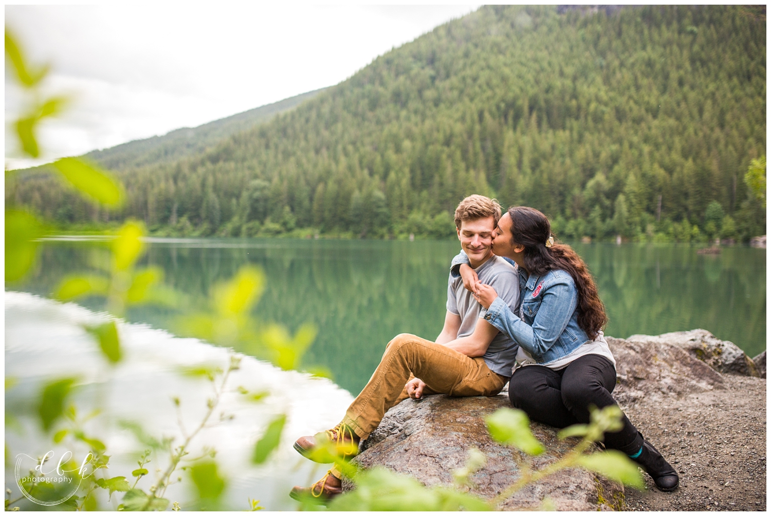 woman kisses her future husband on the cheek by Rattlesnake Lake