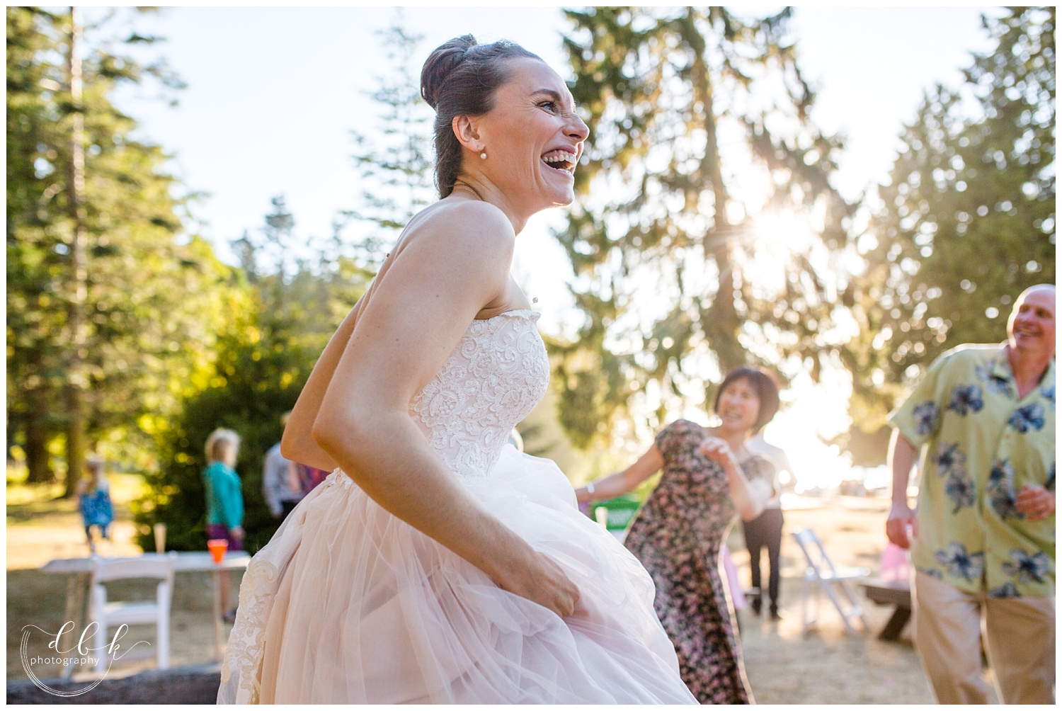 bride laughs as she dances at her Anacortes wedding reception at Washington Park picnic area in Anacortes, Washington