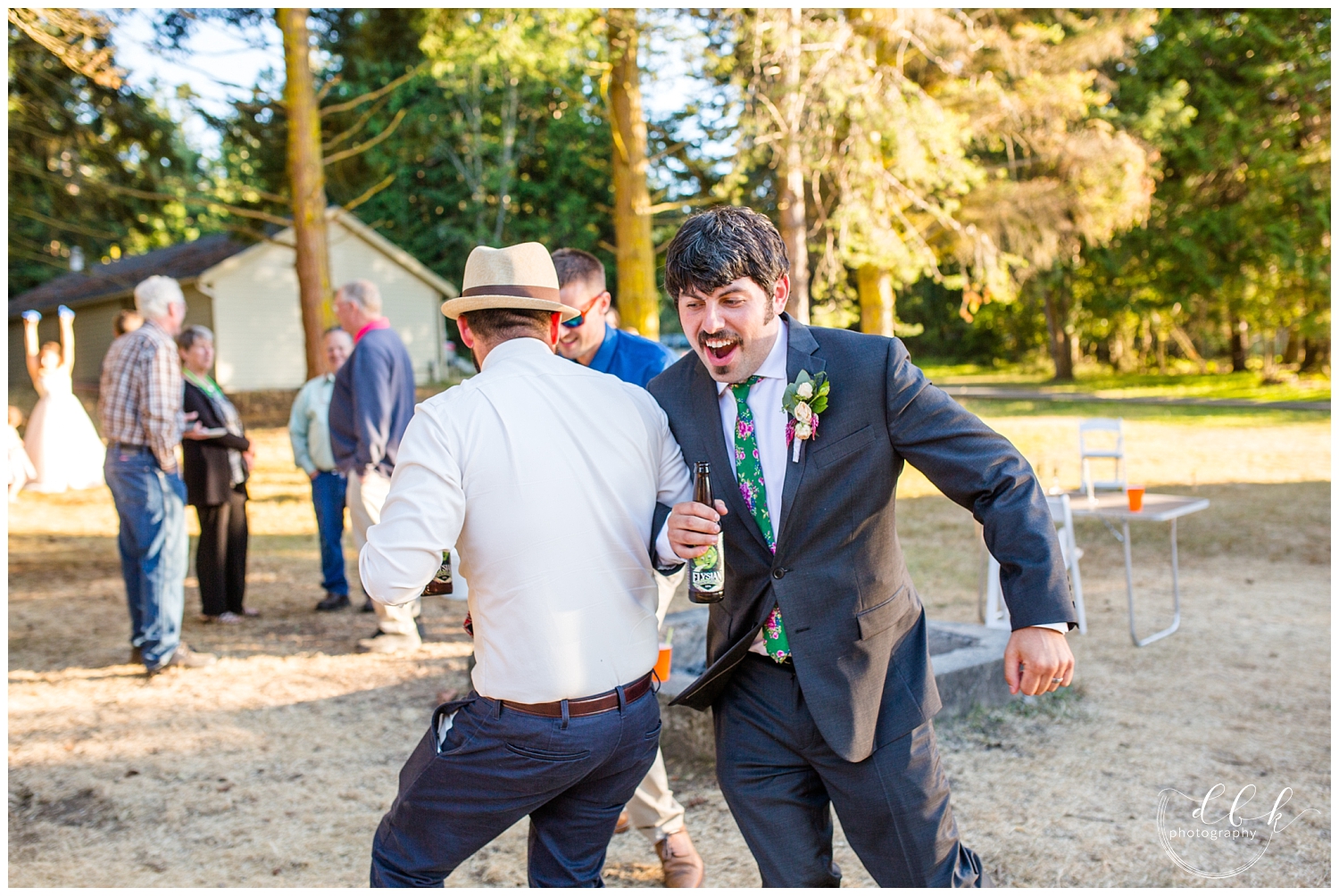 groom swinging around with groomsman during wedding reception at Washington Park picnic area in Anacortes, Washington