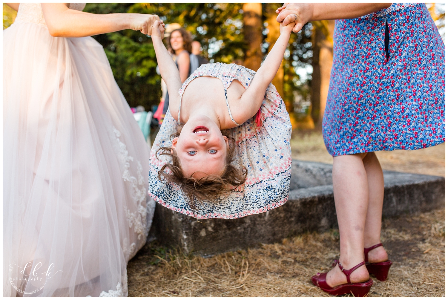 flower girl hanging upside down at Anacortes wedding reception at Washington Park picnic area in Anacortes, Washington