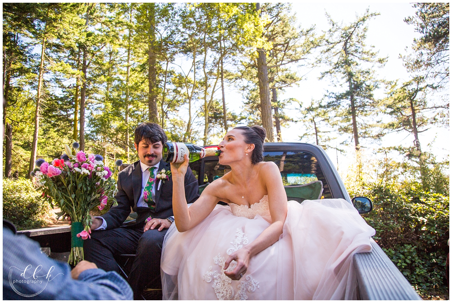 bride in blush pink wedding dress enjoying a sip of champagne from the bottle after wedding ceremony in Washington Park, Anacortes