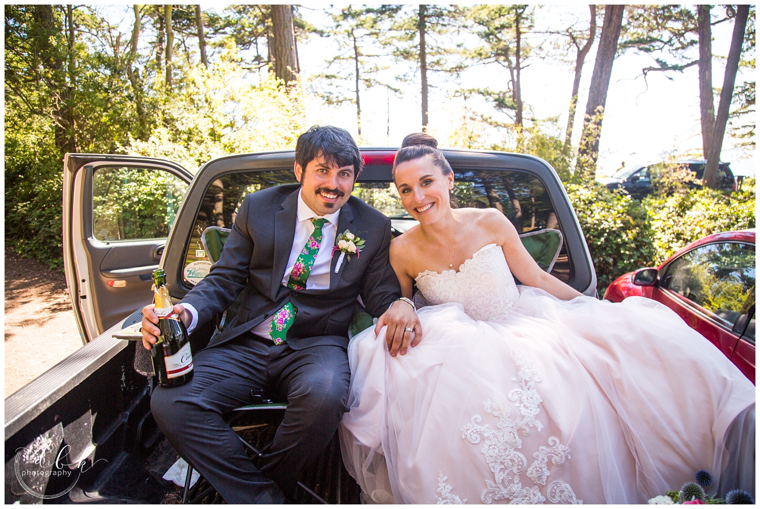 bride and groom sitting in the back of a pickup together after their wedding ceremony at Green Point in Washington Park in Anacortes