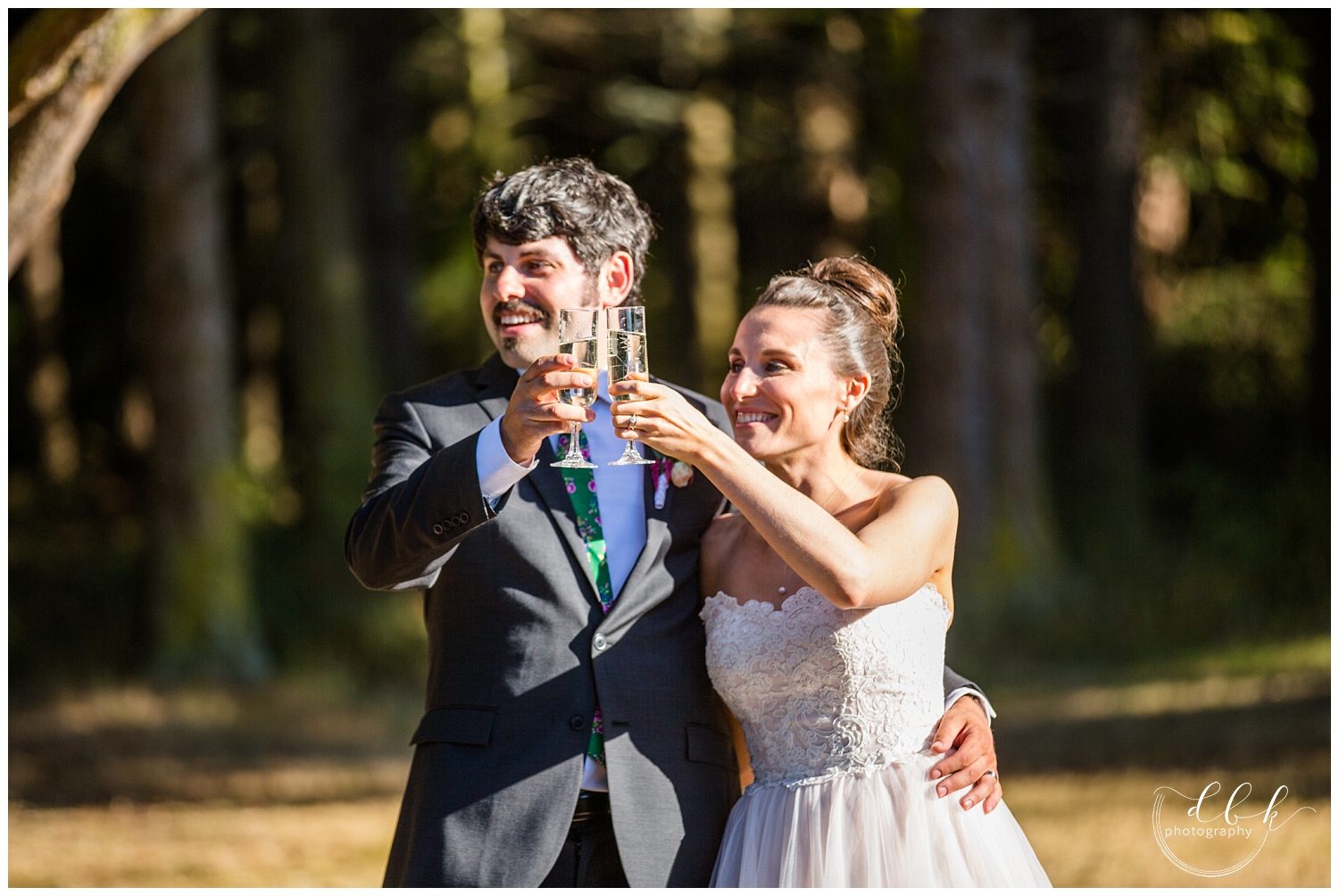 bride and groom clink glasses during toasts at Anacortes wedding in Washington Park picnic area