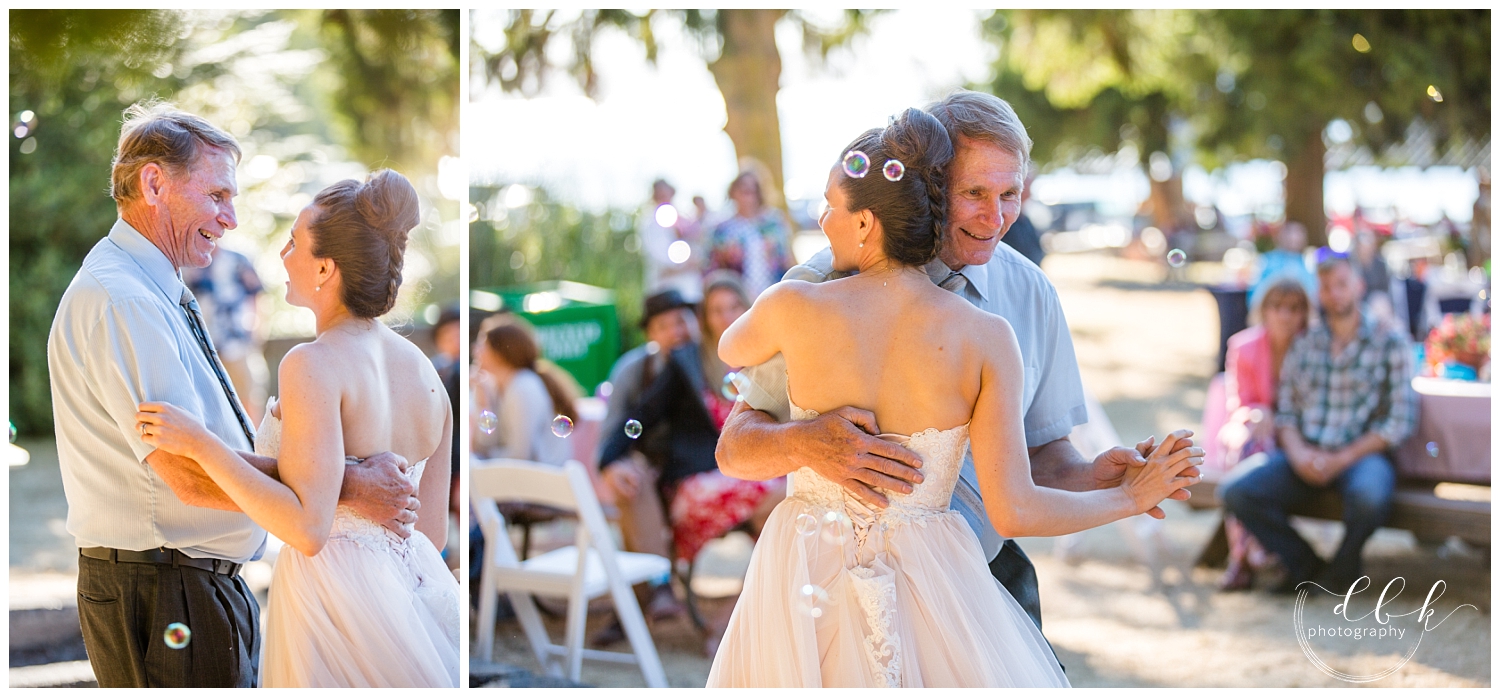 bride and her father share a dance with bubbles blowing at wedding in Washington Park, Anacortes