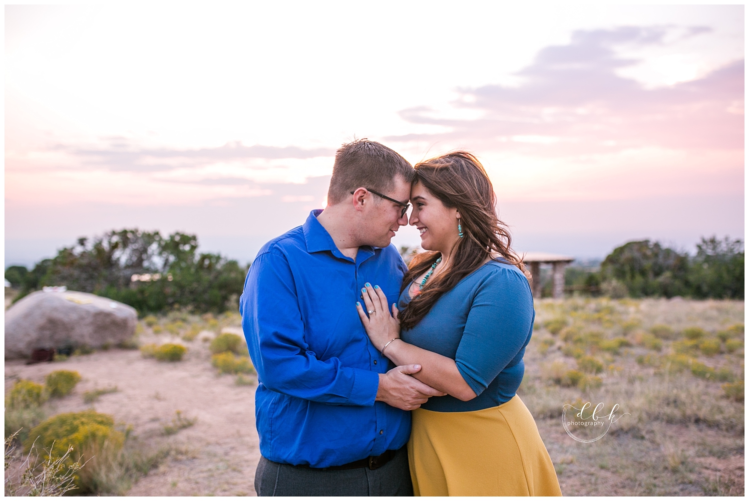 couple touching foreheads in front of sunset over Albuquerque New Mexico