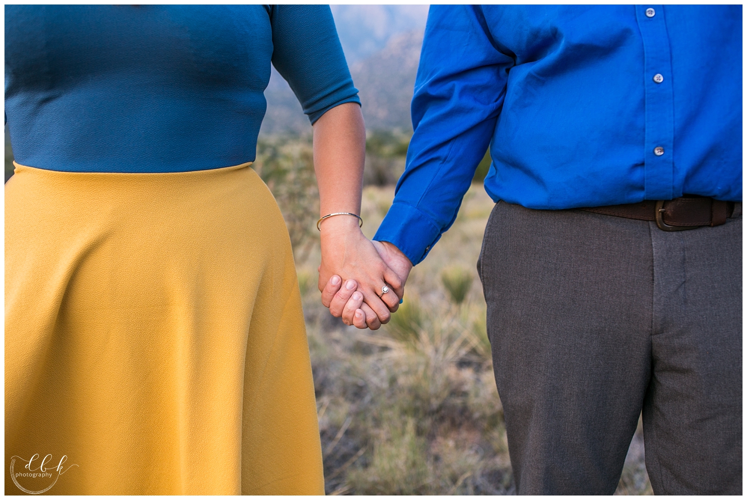 couple wearing blue and yellow holding hands for engagement pictures
