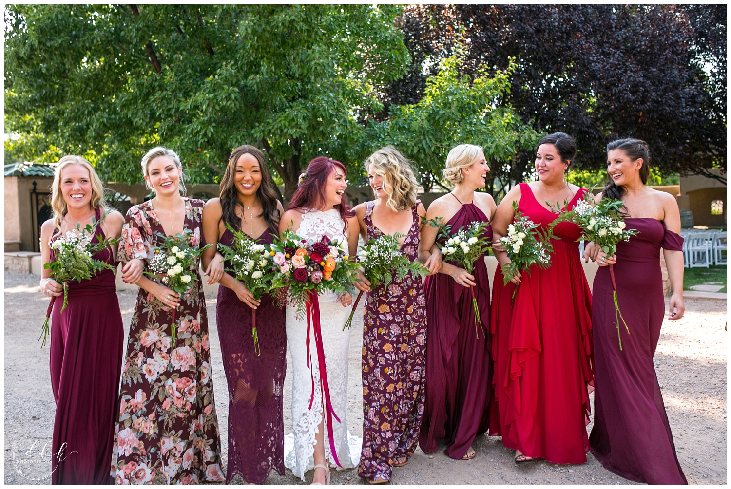 bride walking with bridesmaids wearing long red bridesmaid dresses