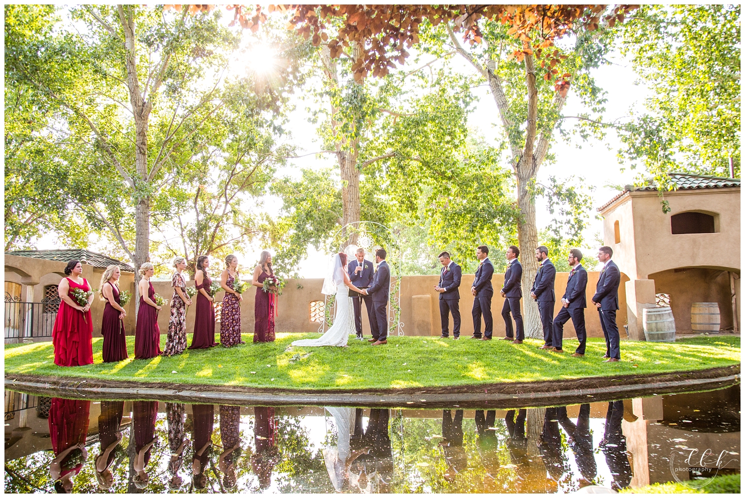 reflection of wedding party in the water at pond at Casa Rondena Winery wedding ceremony