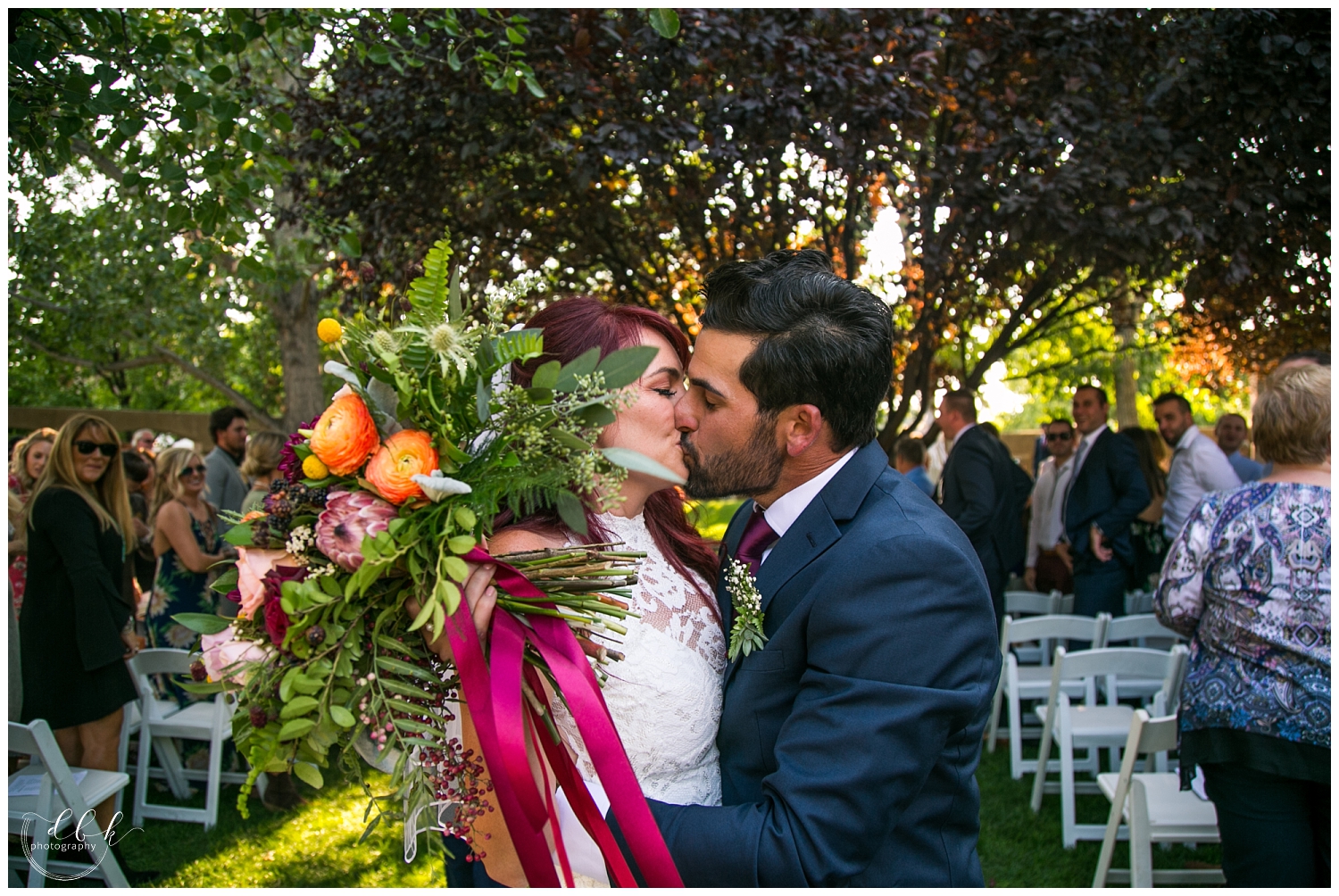 bride and groom kiss as they make their way down the aisle after wedding ceremony at Casa Rondena Winery