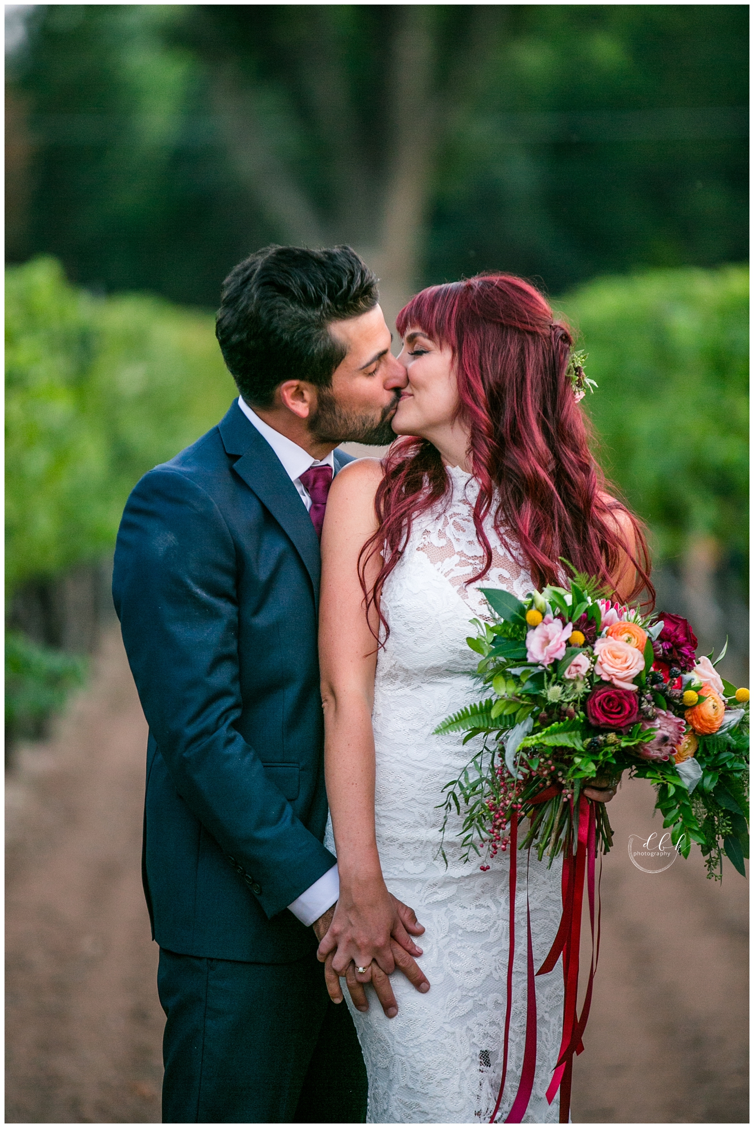 bride and groom kissing in front of grape vines at Casa Rondena Winery in Albuquerque, New Mexico