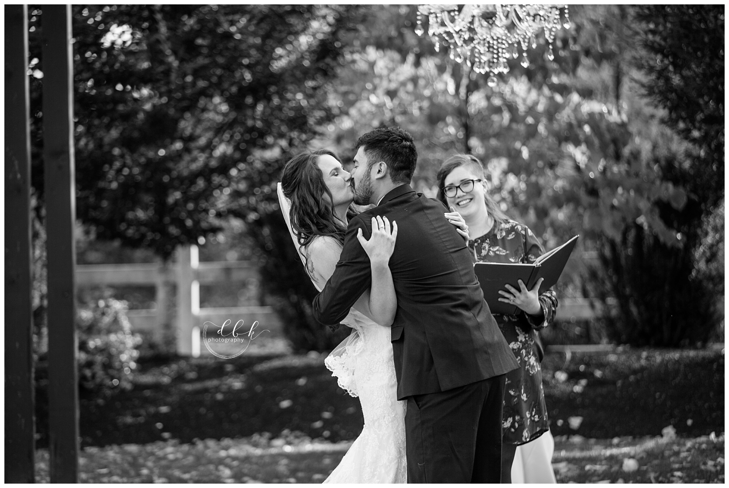 bride and groom's first kiss at fall wedding ceremony at Filigree Farm in Buckley, Washington