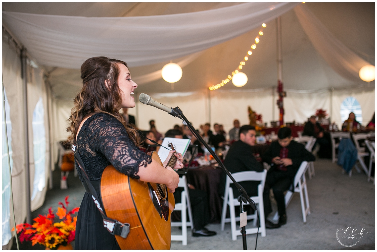 bridesmaid singing a song for the bride and groom's first dance at fall Filigree Farm wedding reception