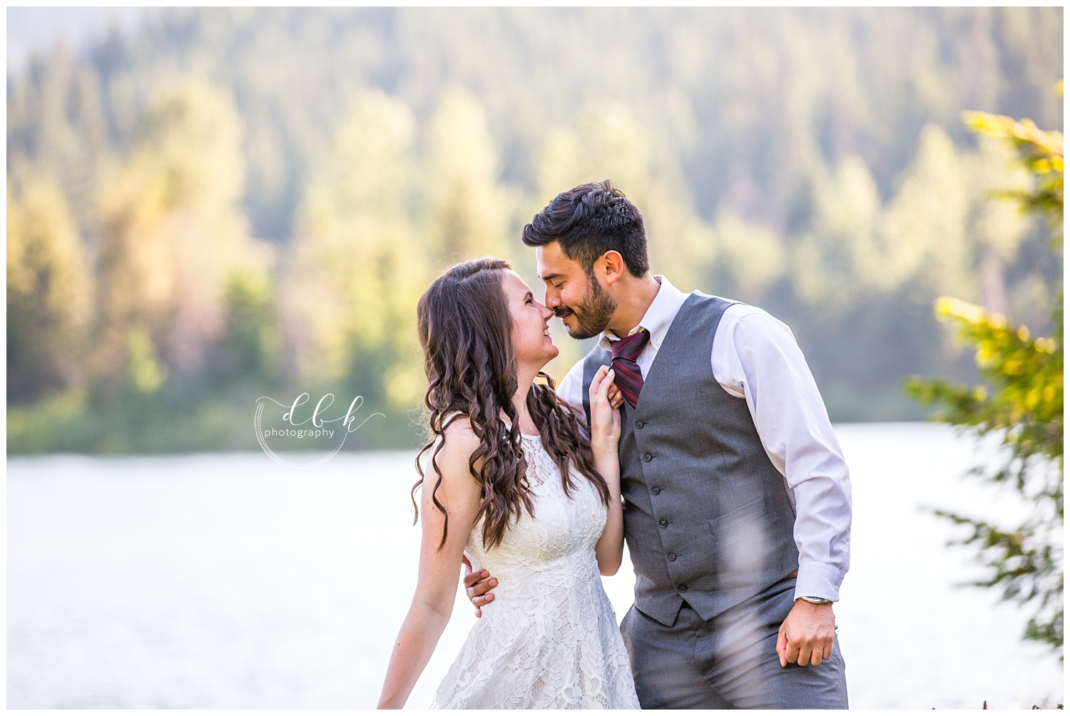 bride pulling her groom into her by his tie at Gold Creek Pond