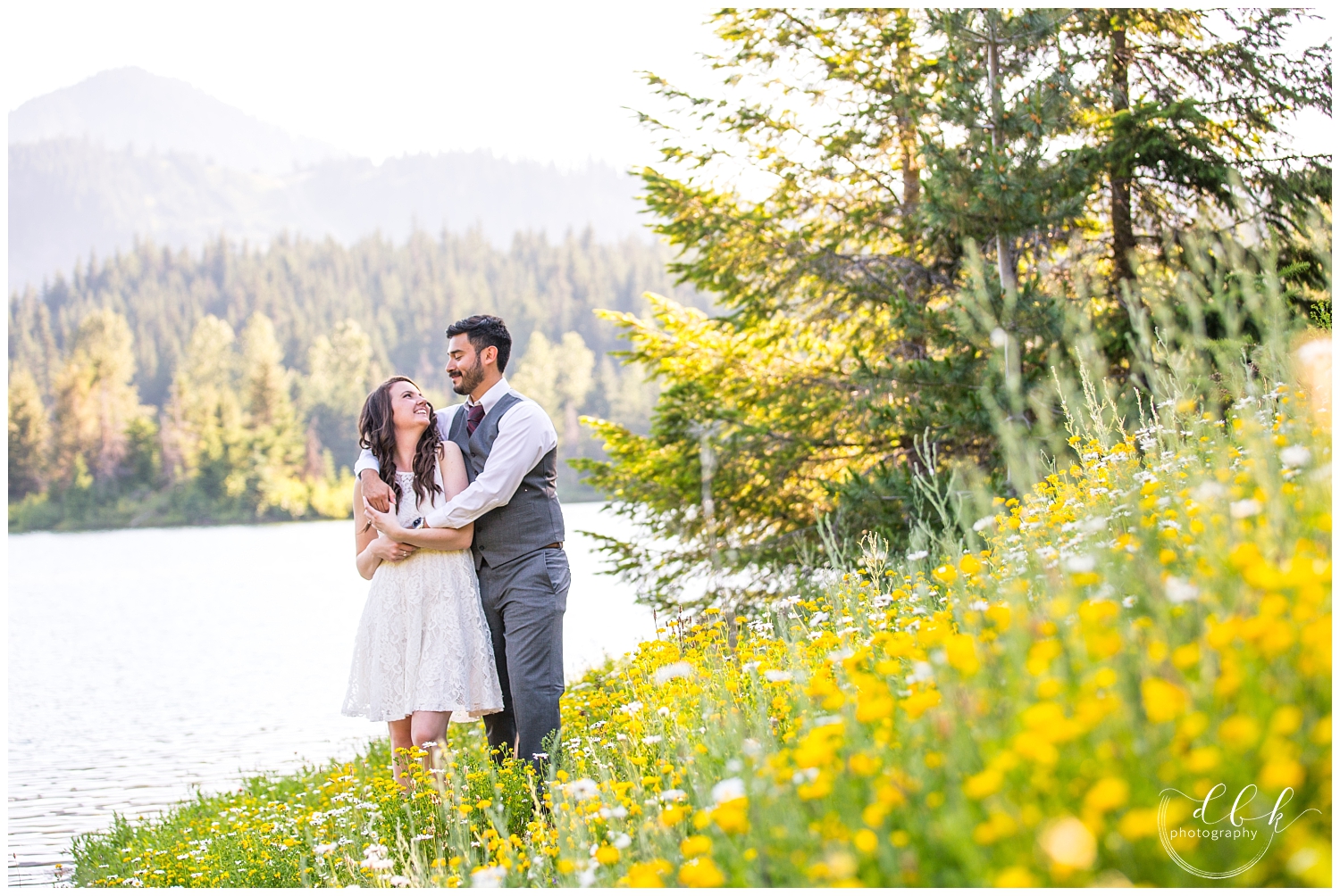 couple standing on a hill of wildflowers at Gold Creek Pond in Washington