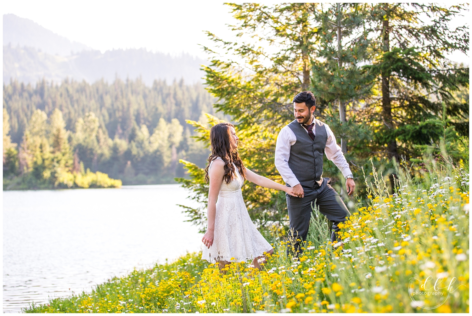 couple walking up a hill of wildflowers at Gold Creek Pond in Washington