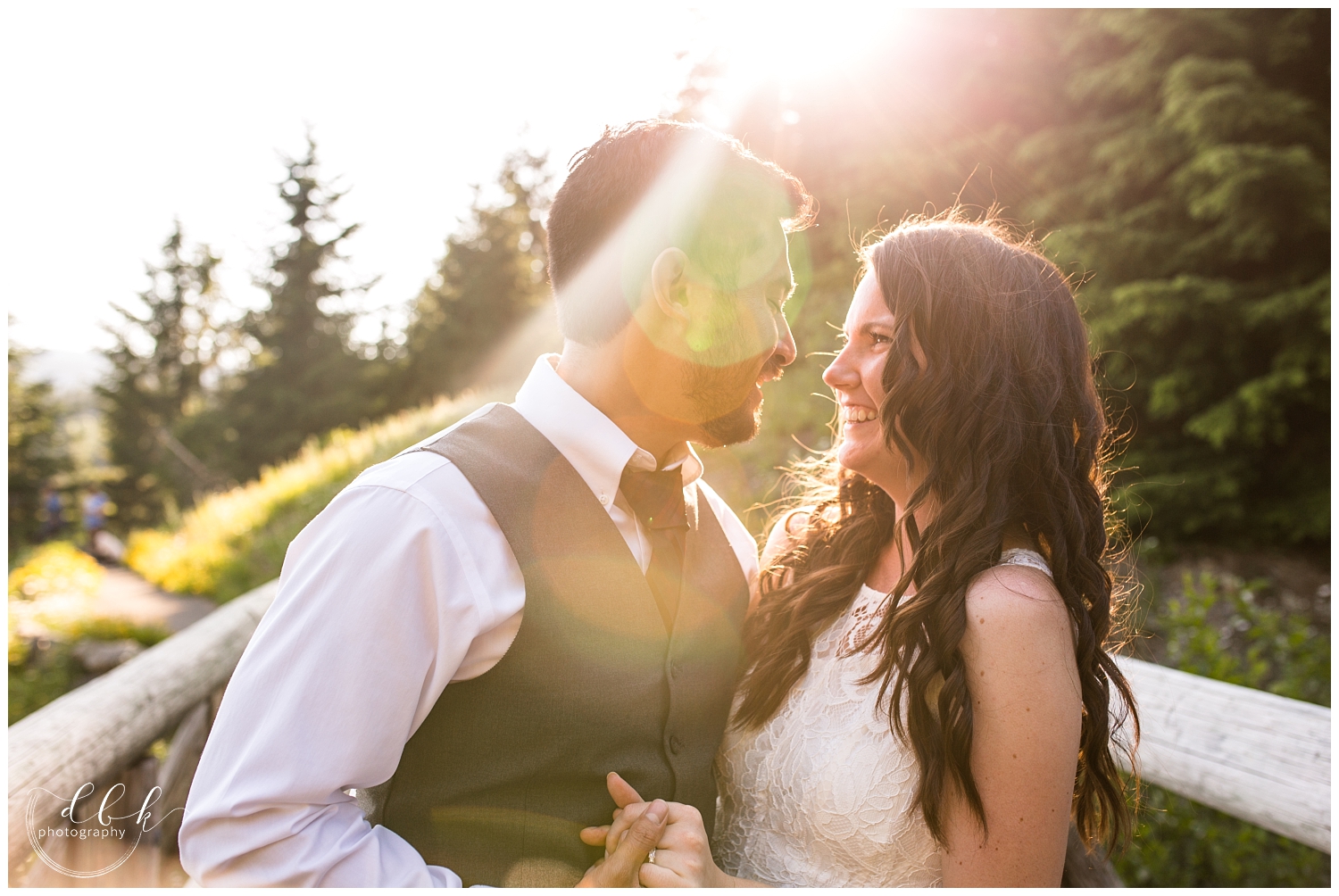 bride and groom laughing together in the sunshine during summer engagement portraits at Gold Creek Pond