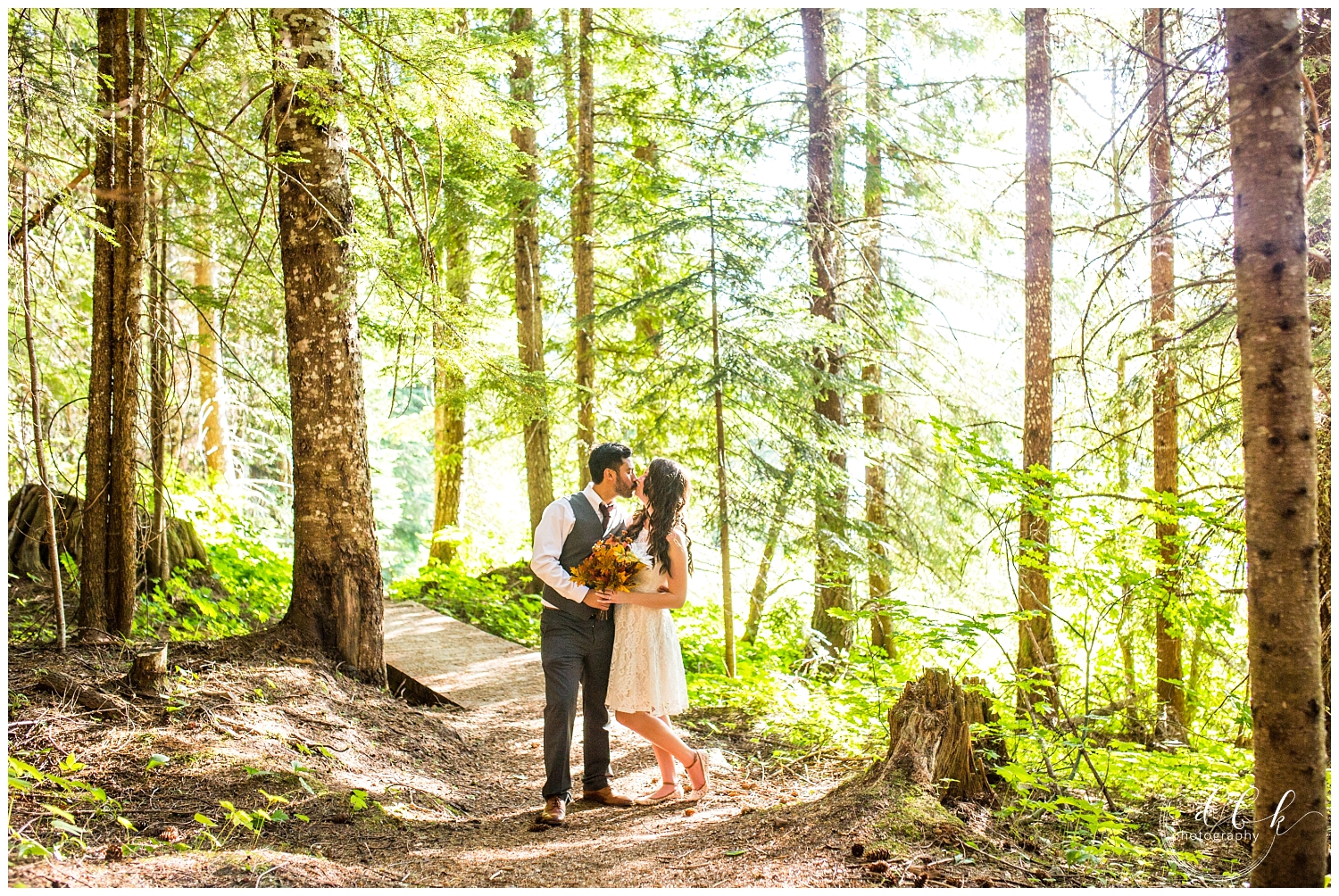 wedding couple kissing on a forest trail