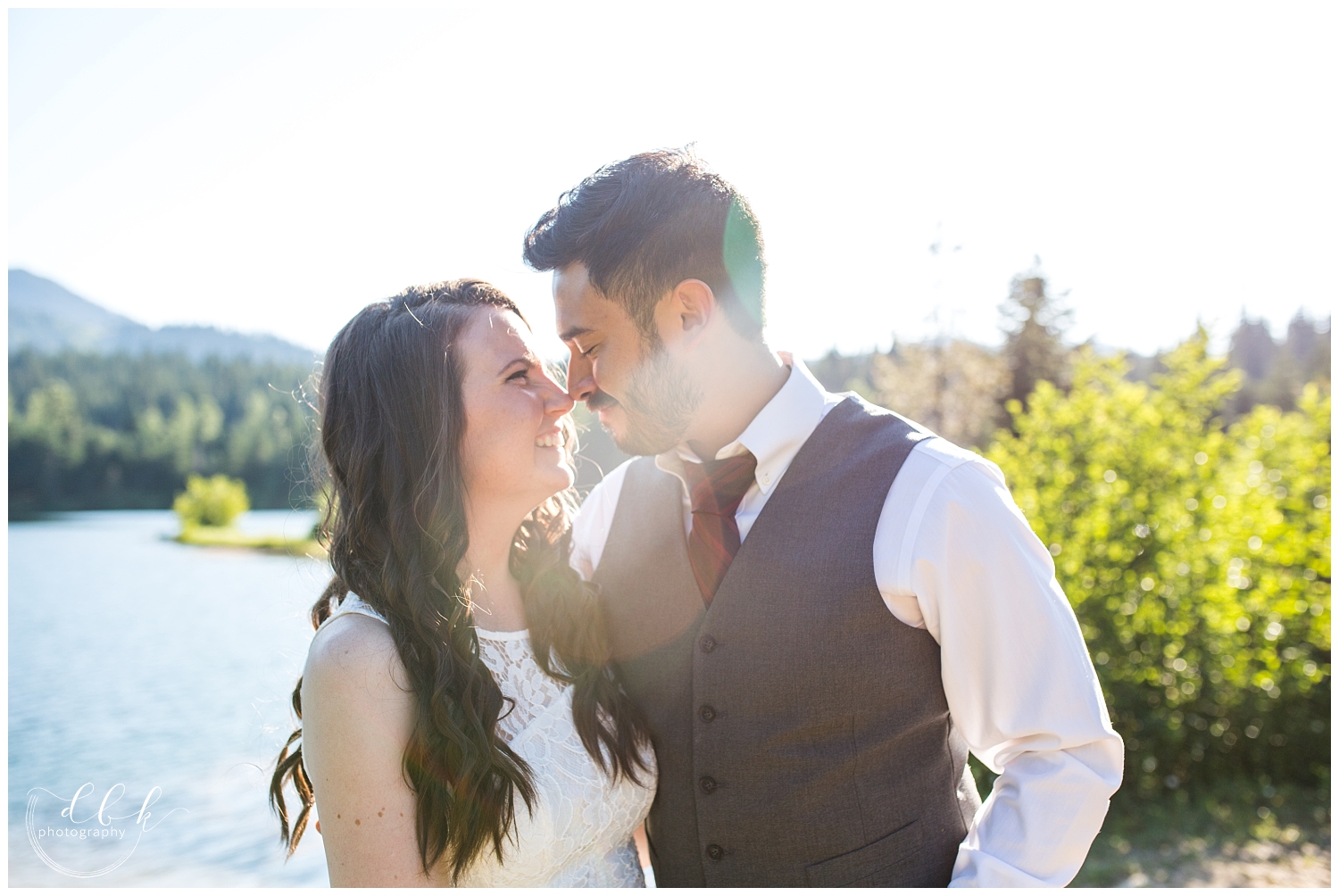 backlit shot of couple touching noses for summer engagement portraits at Gold Creek Pond