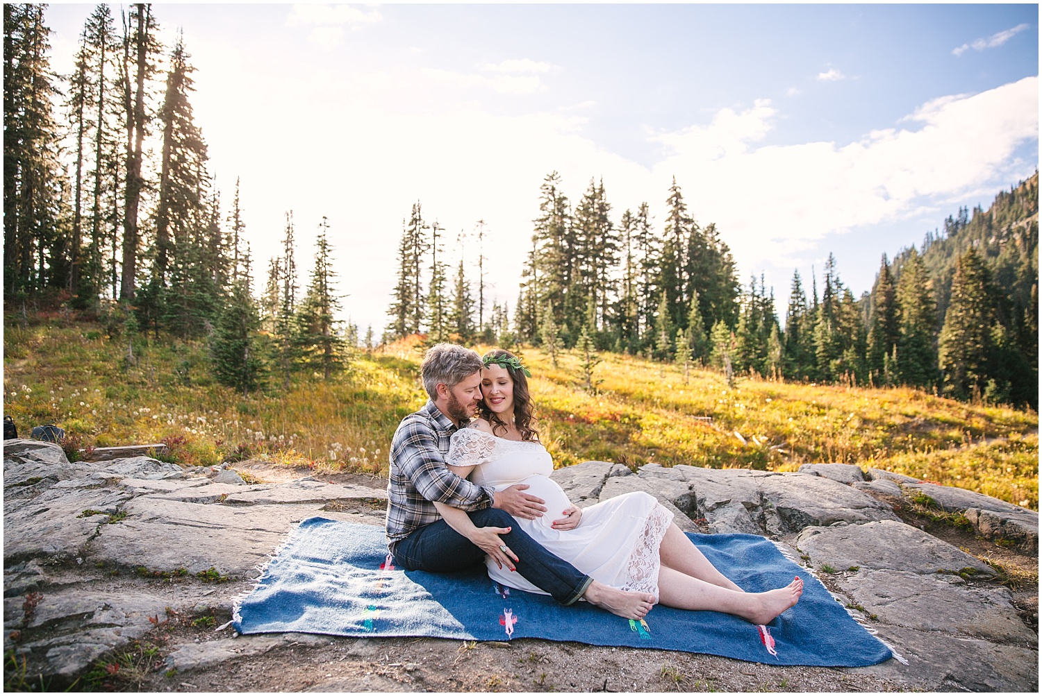 Couple sitting on blanket for fall maternity pictures at Mount Rainier National Park