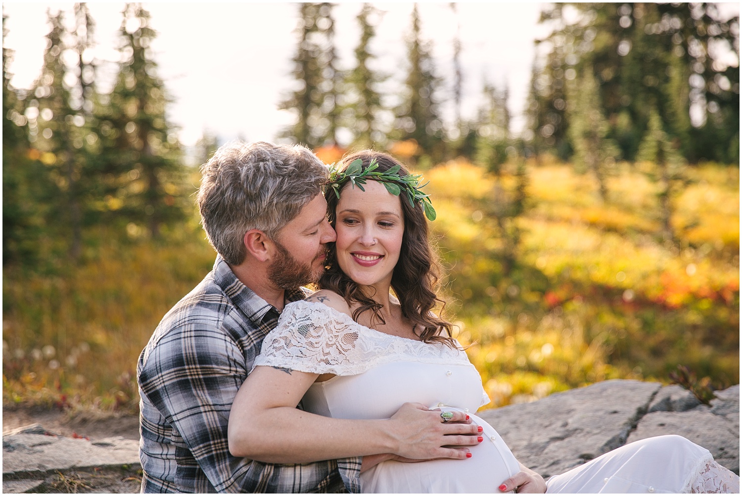 Couple sitting on blanket for fall maternity pictures at Mount Rainier National Park