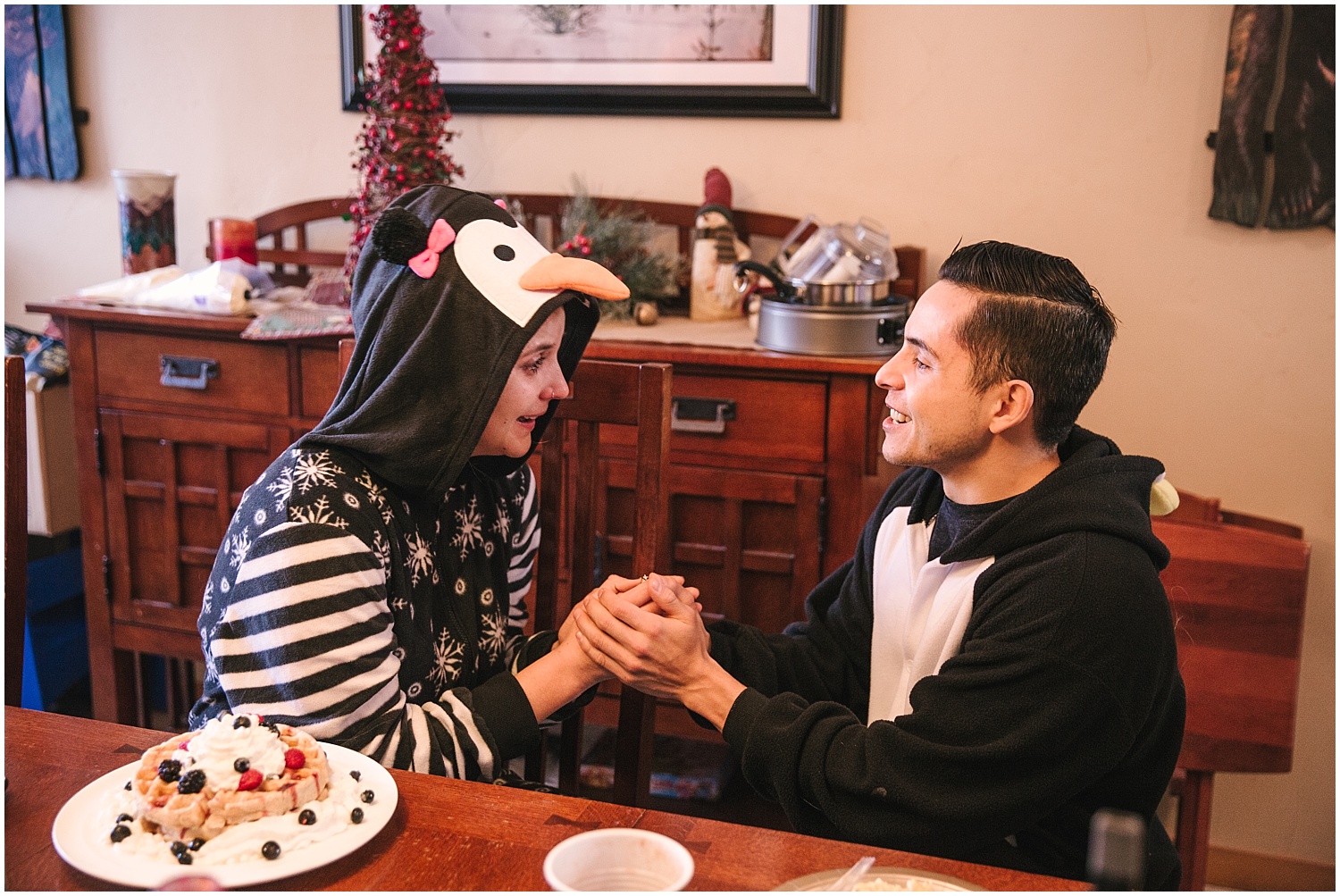 Couple wearing matching penguin onesies for surprise proposal at Winter Park, Colorado