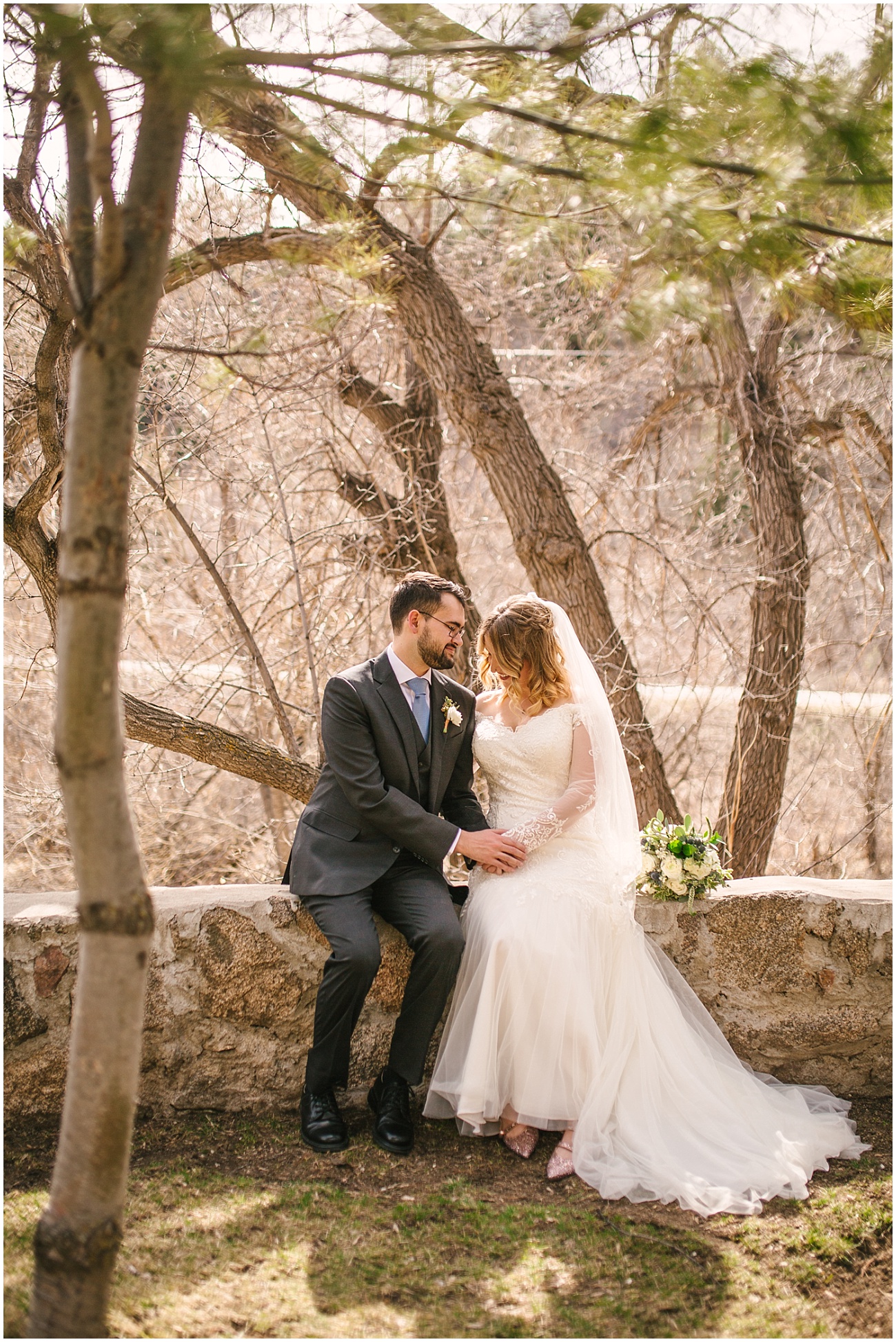 Bride and groom sit by the creek at Wedgewood Weddings Boulder Creek