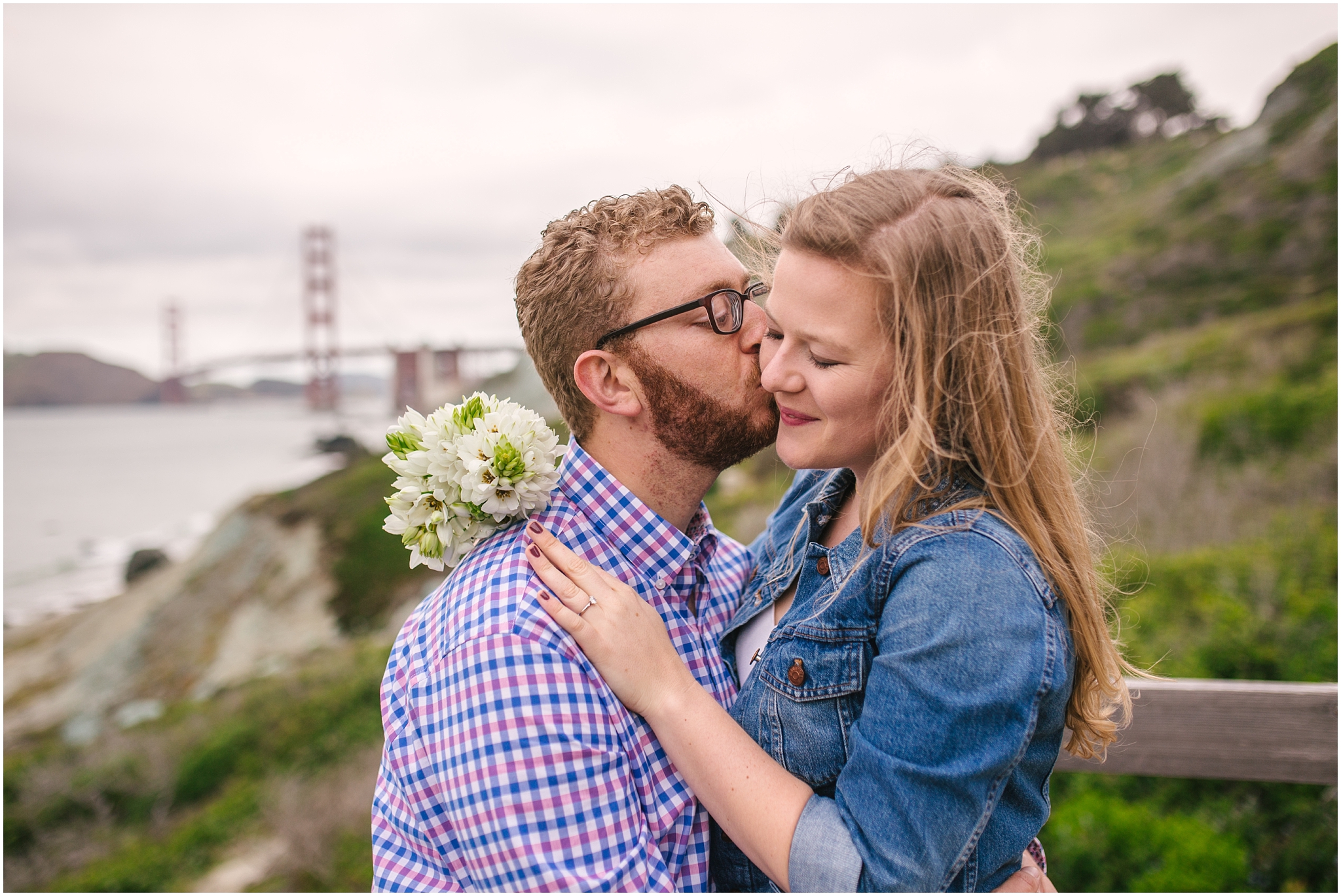 Couple standing in front of Golden Gate Bridge for Marshall Beach San Francisco engagement pictures