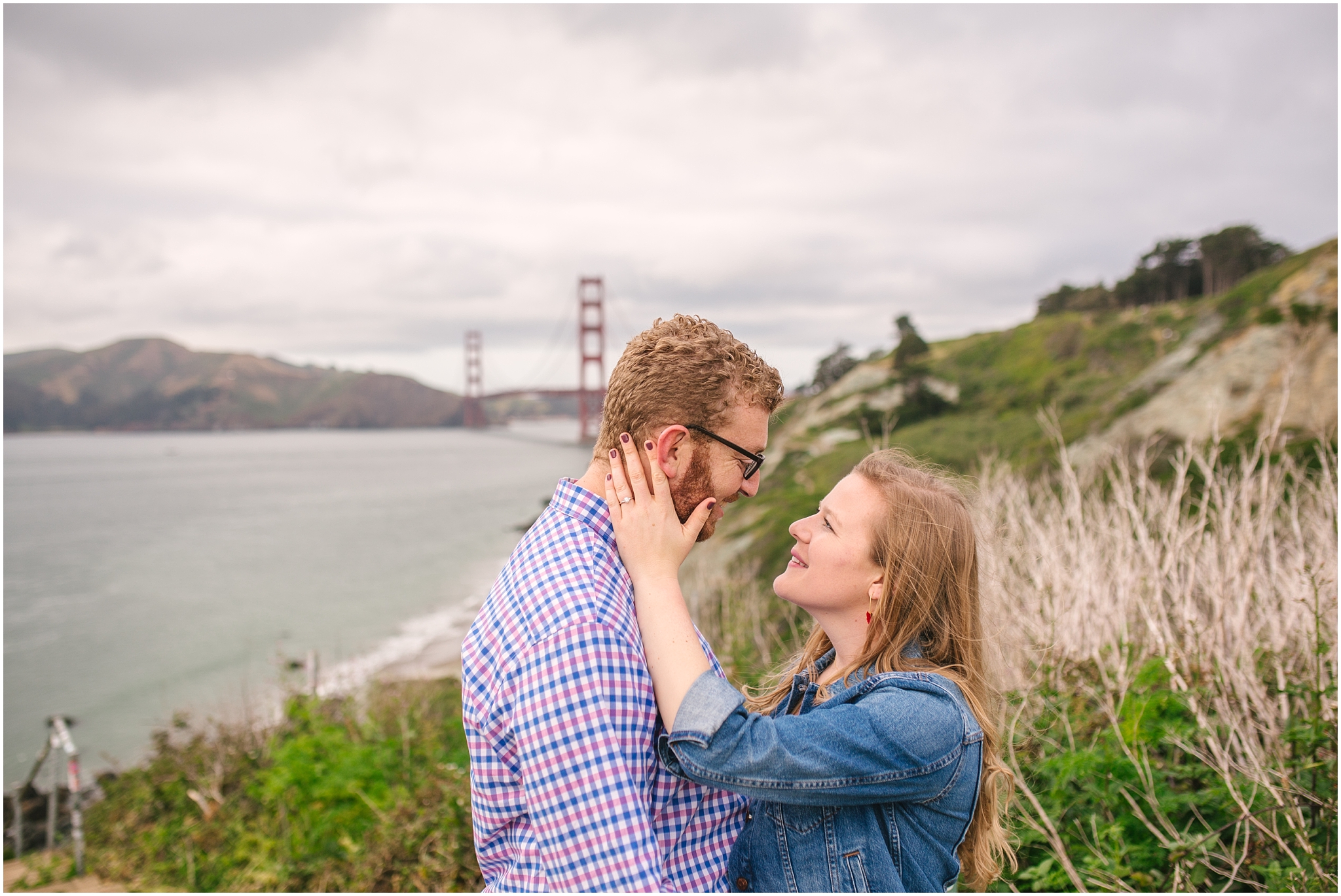 Couple standing in front of Marshall Beach and Golden Gate Bridge