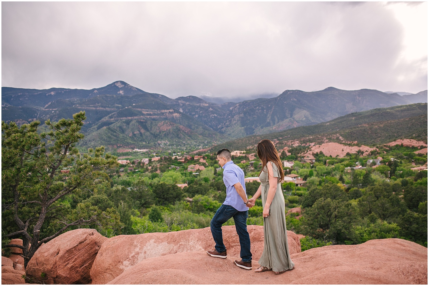Couple walking across red rocks at Garden of the Gods in Colorado Springs