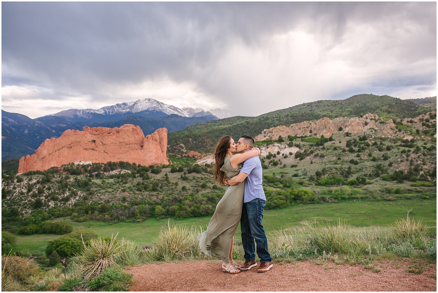 Couple kissing overlooking Garden of the Gods and Pikes Peak in Colorado Springs engagement photos