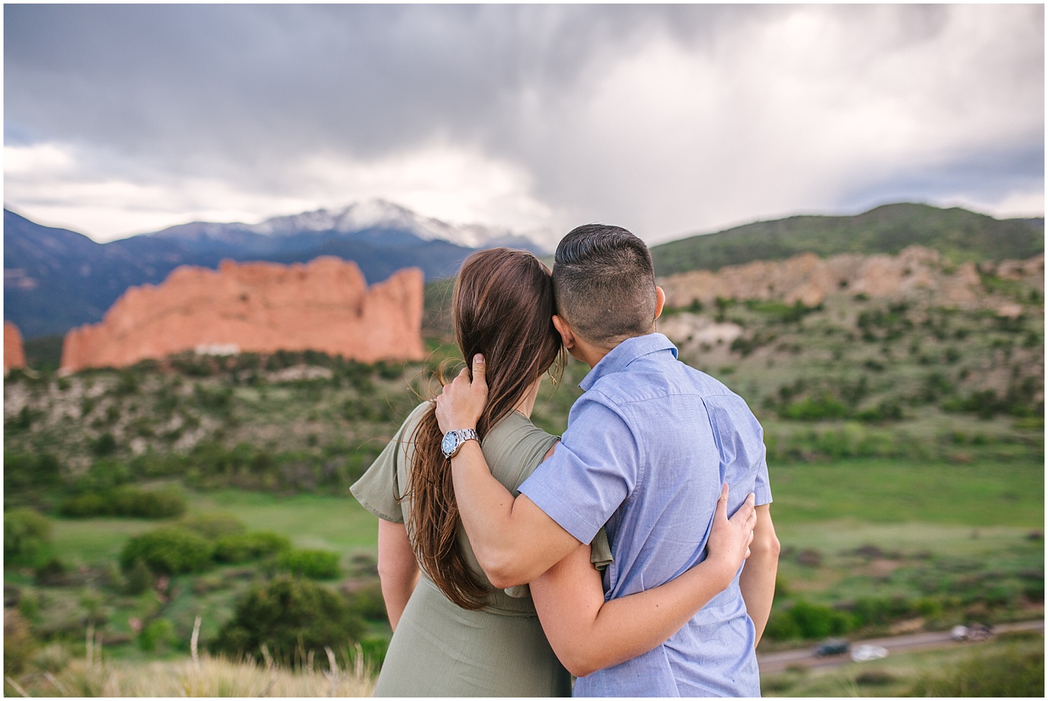 Couple at overlook Garden of the Gods and Pikes Peak in Colorado Springs engagement photos