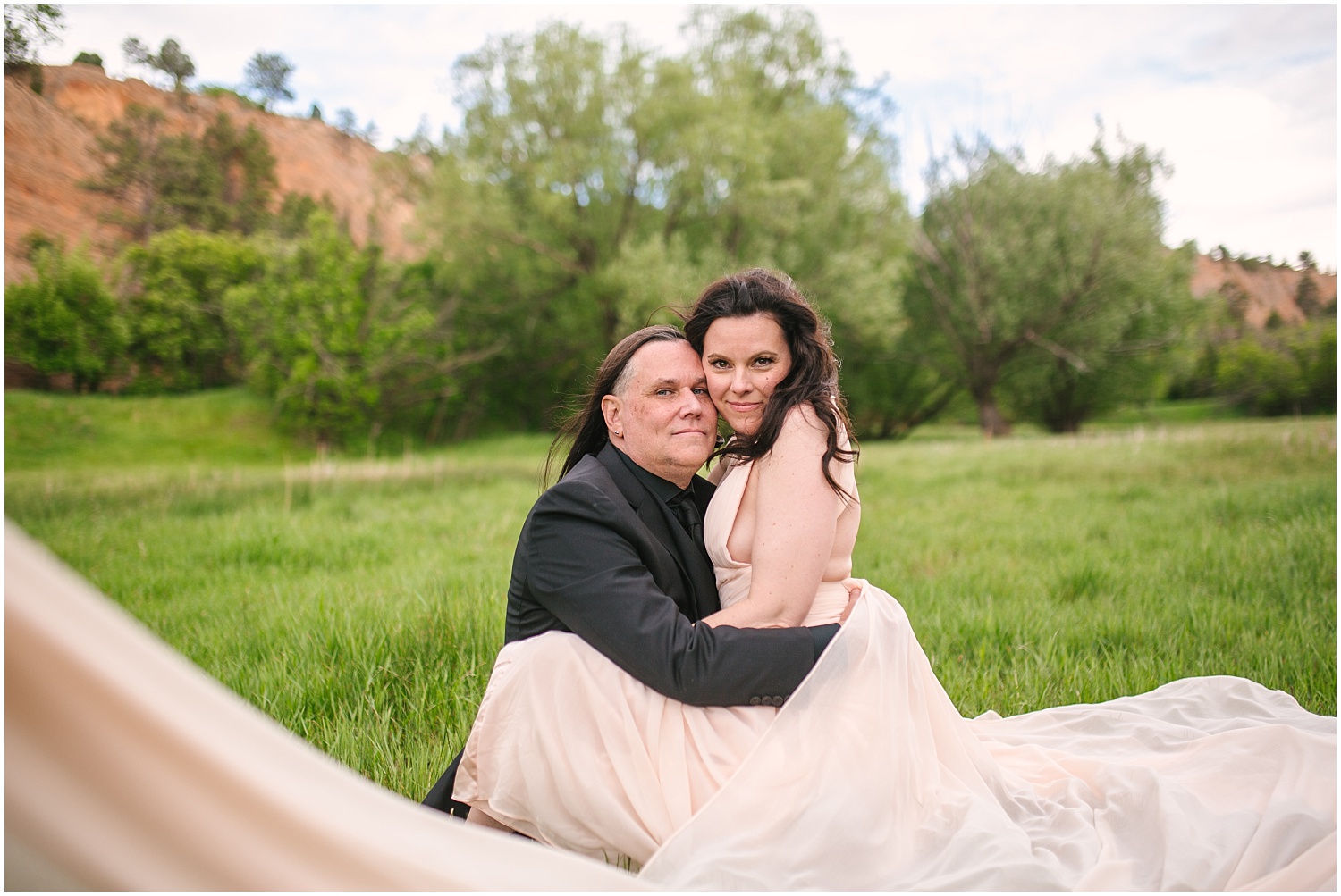 Couple cuddling in the grass for Red Rock Canyon Open Space engagement photos in Colorado Springs