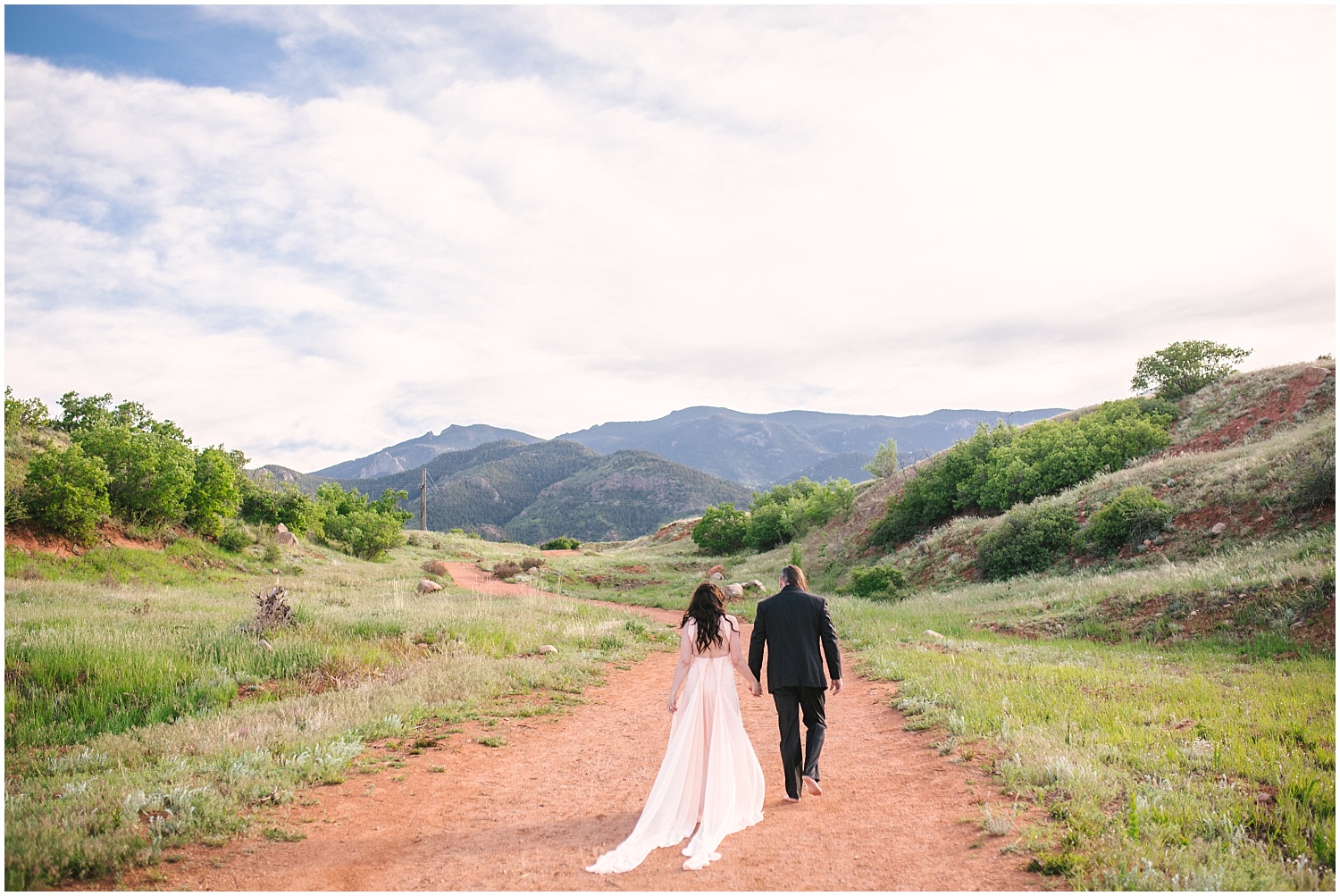 Couple walking along dirt path for Red Rock Canyon Open Space engagement photos