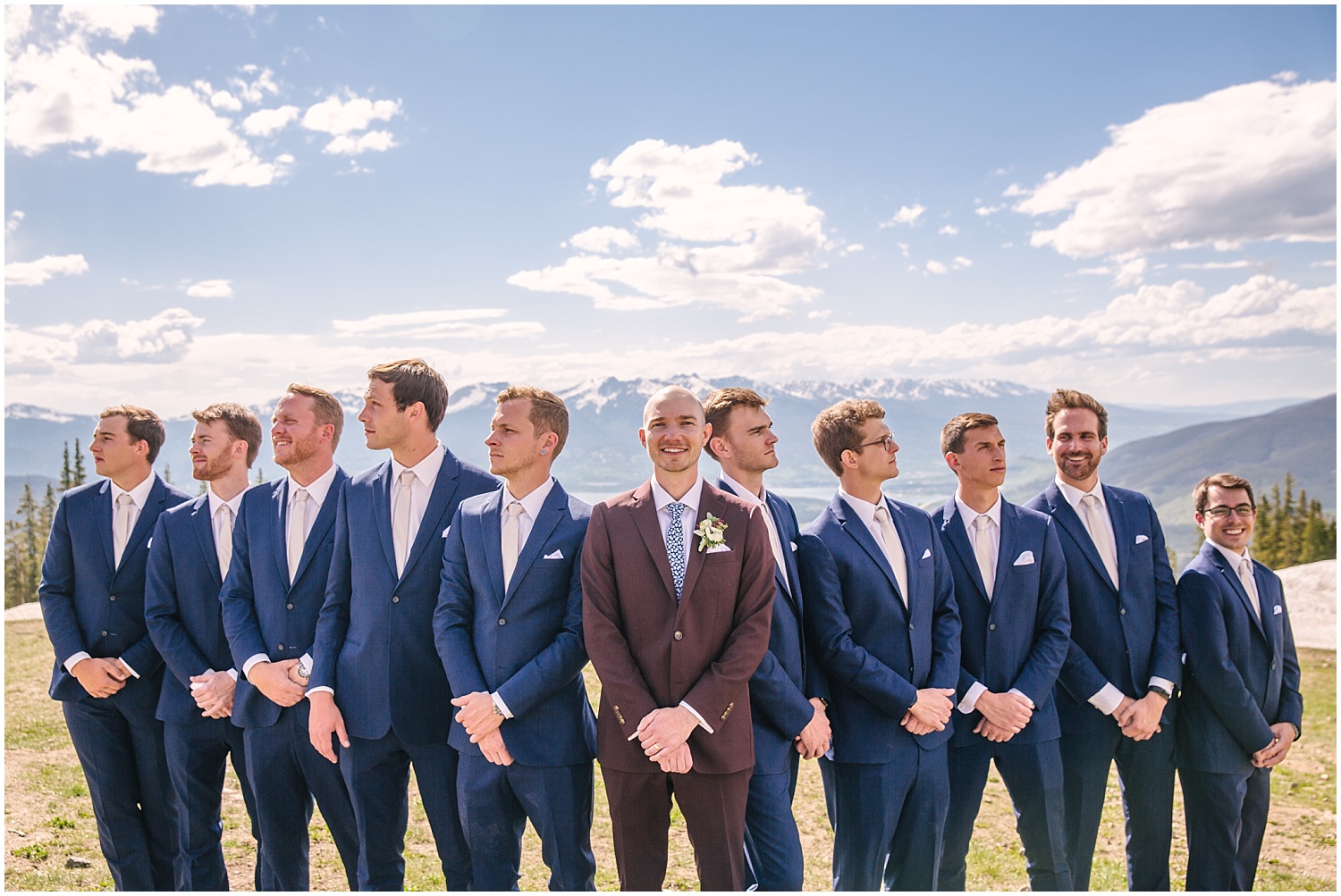 Groom in maroon and groomsmen in dark navy suits for Keystone Colorado wedding