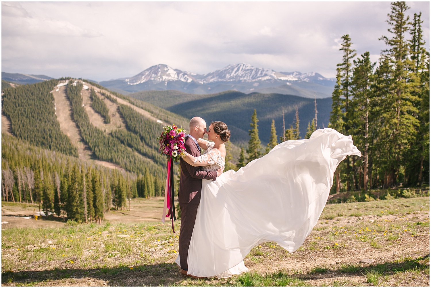 Bride's dress blows in the wind at summit of Keystone Colorado for Ski Tip Lodge wedding