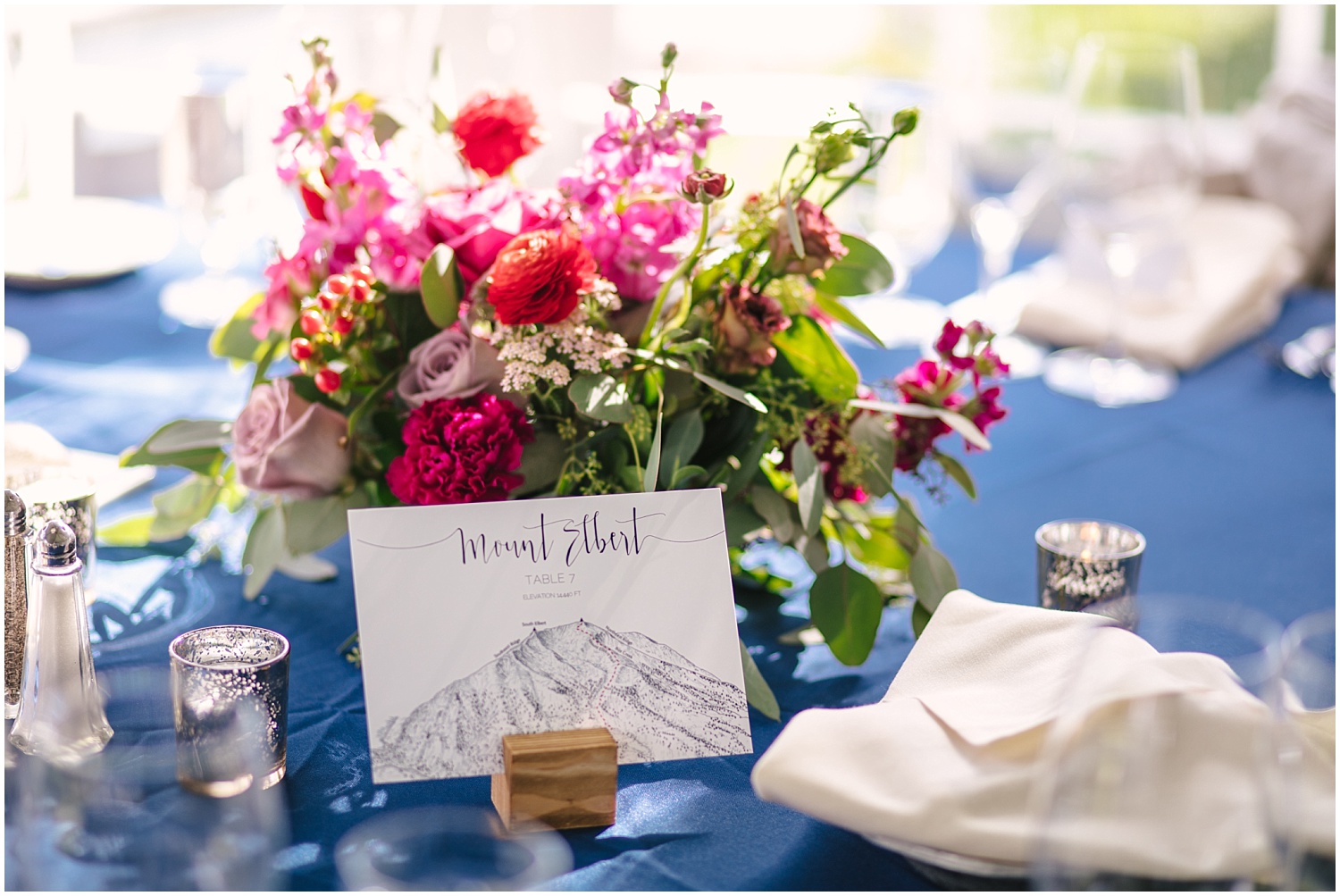 Mountain place cards and pink bouquet centerpieces at Ski Tip Lodge wedding in Keystone Colorado