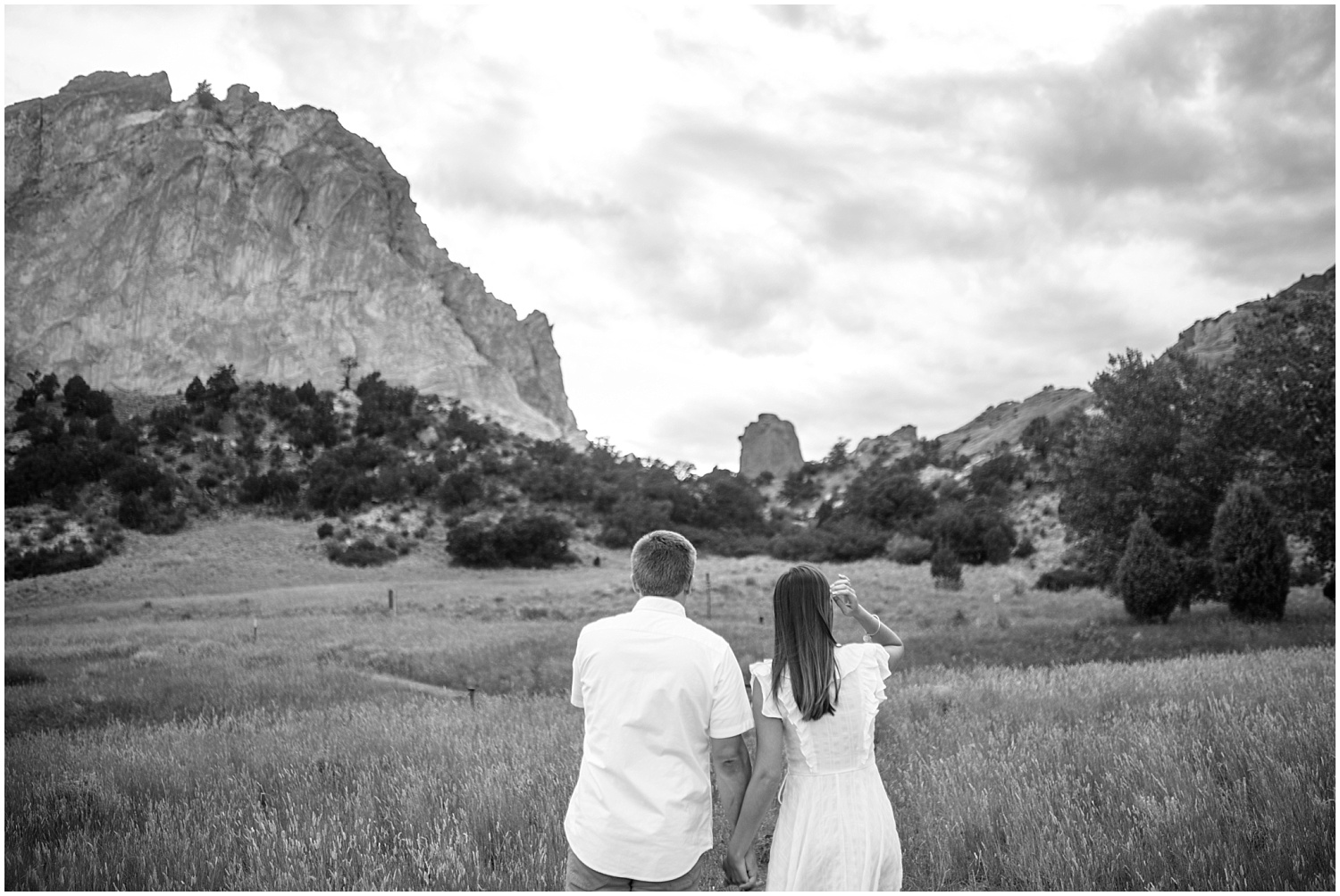 Couple walking in a field for Garden of the Gods engagement photos