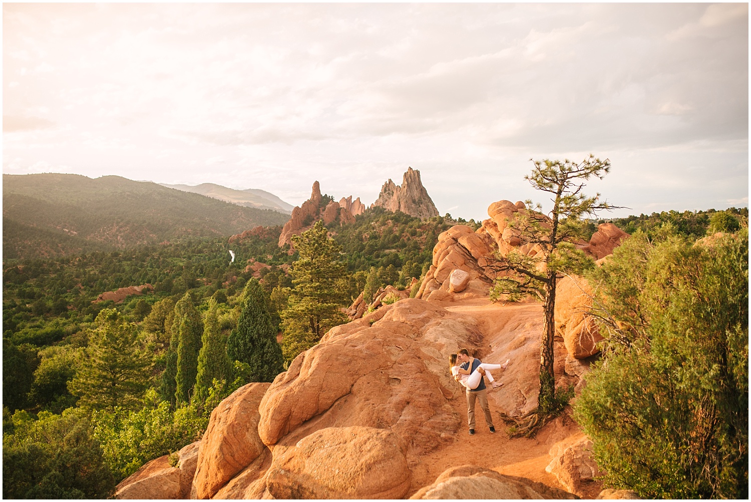 Wide landscape photo of couple at golden hour at Garden of the Gods