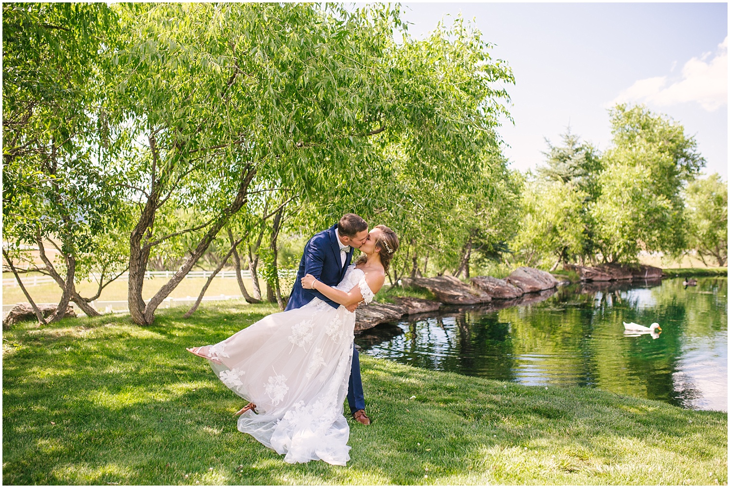Bride and groom kissing by the trees and pond at Crooked Willow Farms wedding