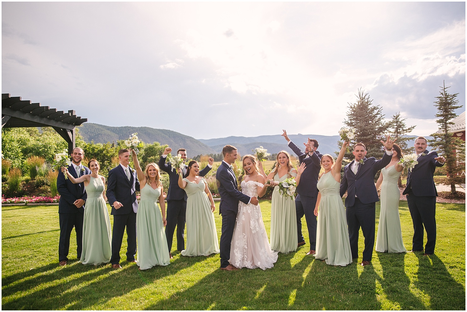 Wedding party wearing navy and sage green overlooking the Rocky Mountains at Crooked Willow Farms in Larkspur Colorado
