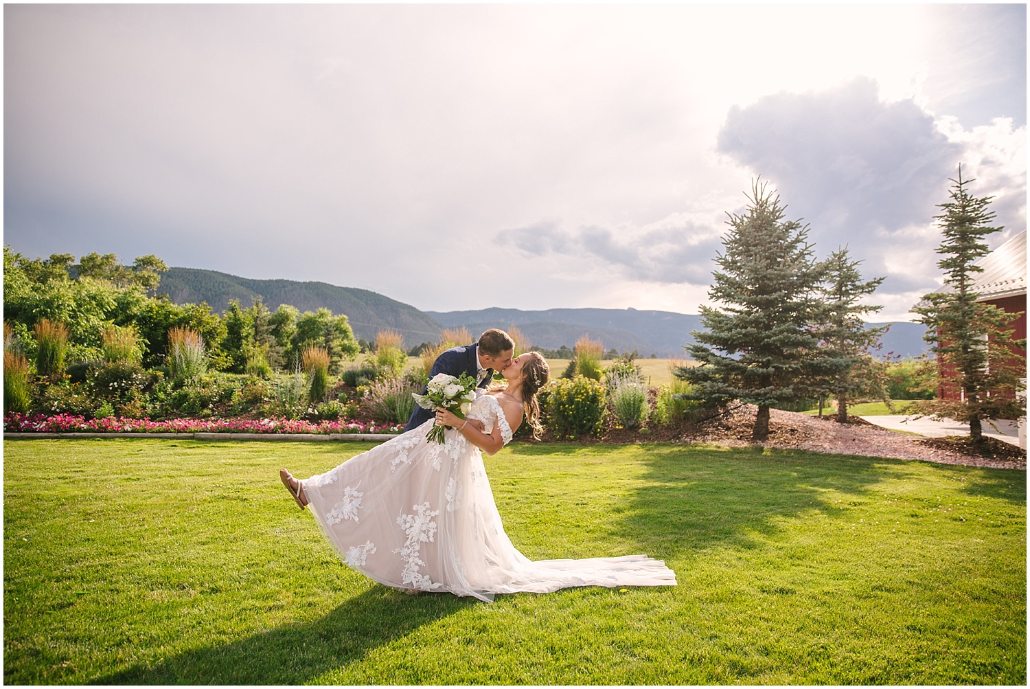 Bride and groom kissing in front of the Rocky Mountains at Crooked Willow Farms in Larkspur Colorado