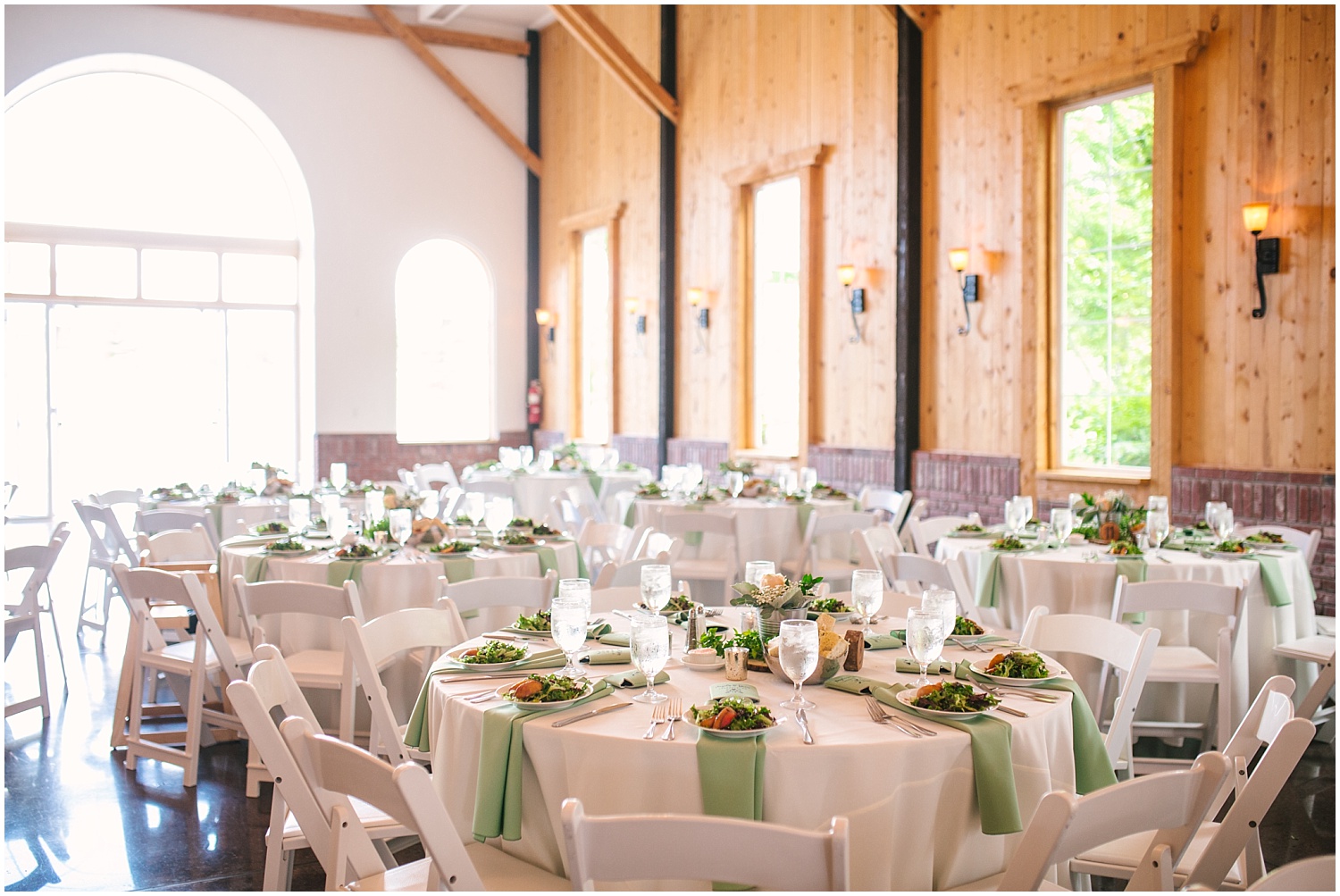 Wood table numbers with white flowers and greenery as centerpieces at Crooked Willow Farms wedding