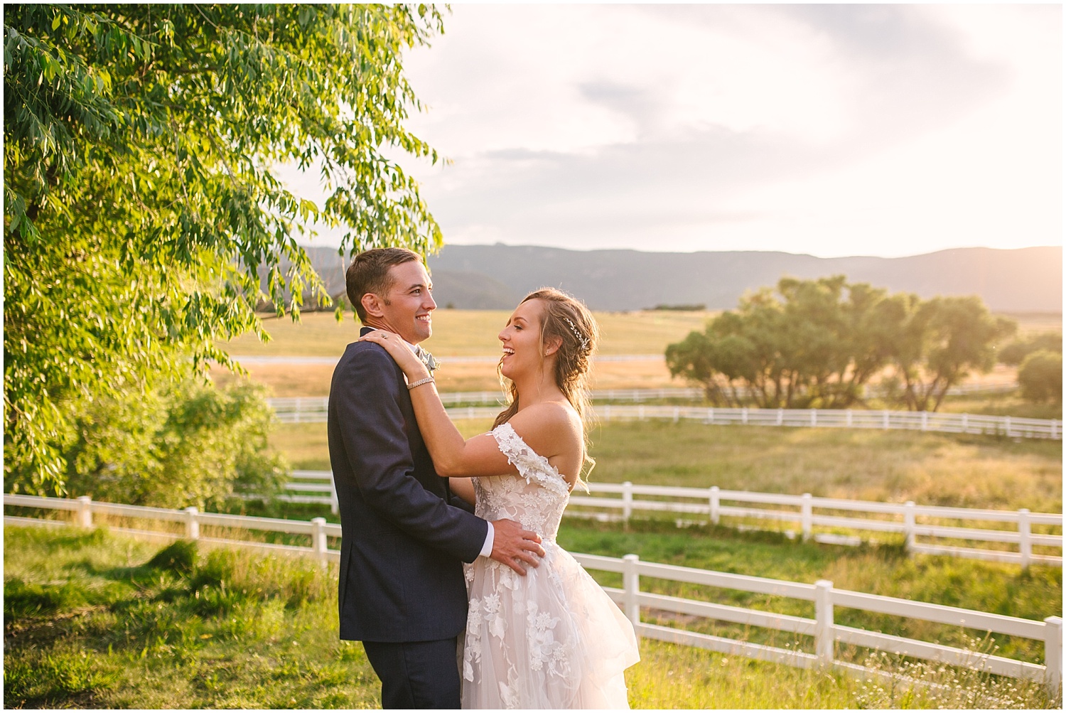 Bride and groom dance together at sunset overlooking the fields surrounding Crooked Willow Farms