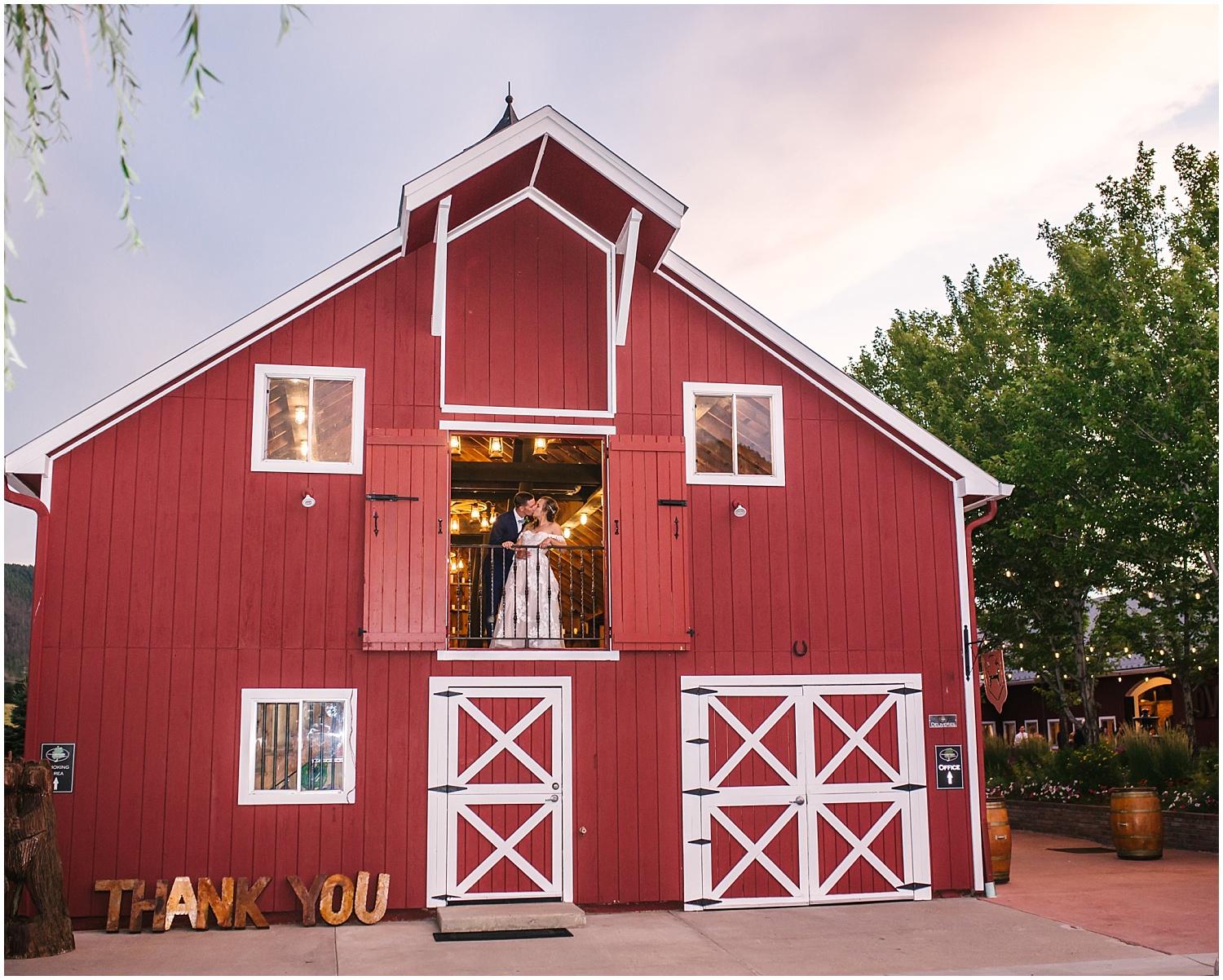 Bride and groom kissing in the red barn at Crooked Willow Farms