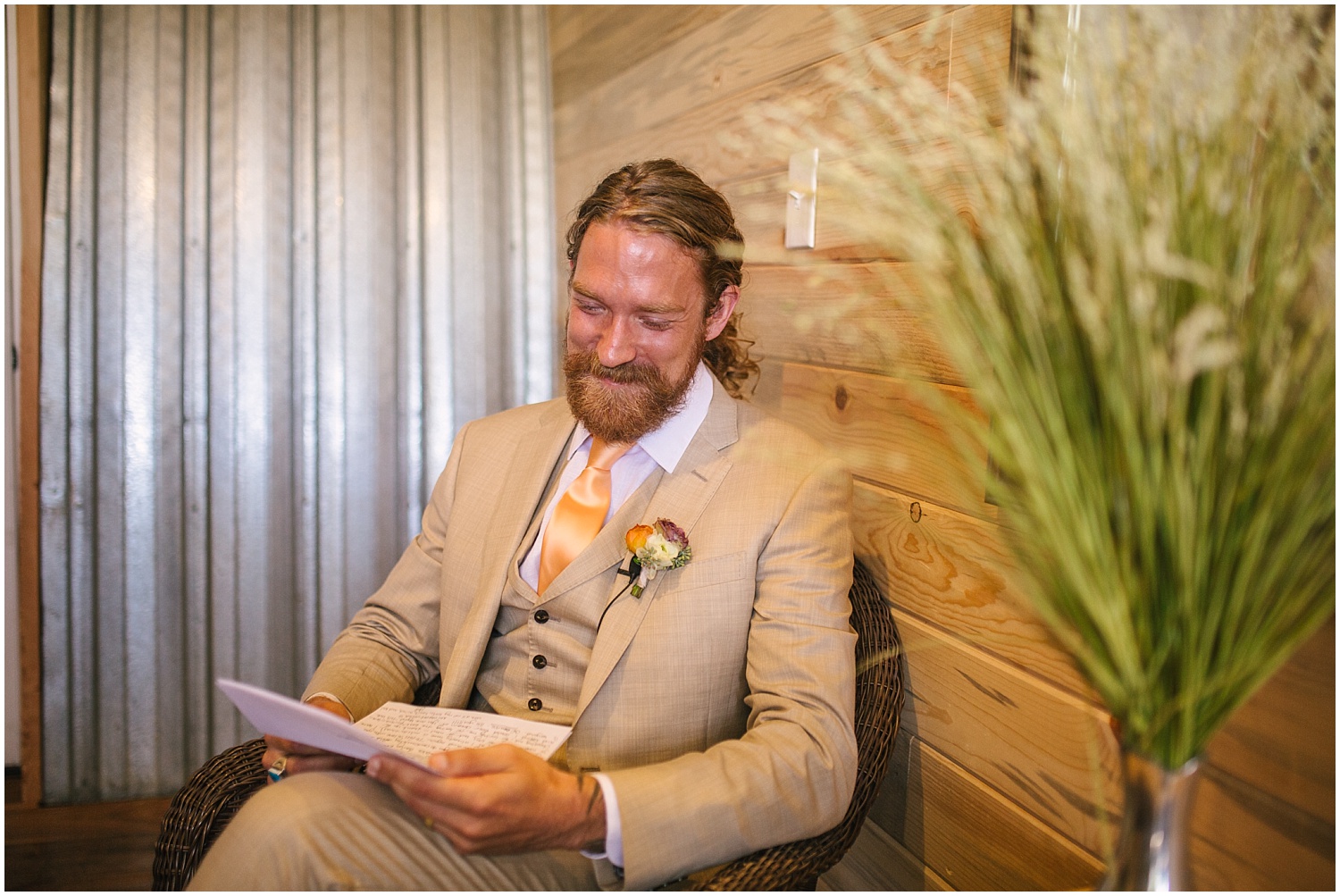 Groom reads a letter from his bride before Lone Hawk Farm wedding in Longmont Colorado