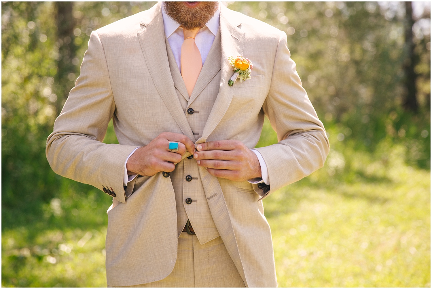 Groom in custom taupe suit by The Bespoke Edge, with coral tie and turquoise ring, at Lone Hawk Farm in Longmont Colorado